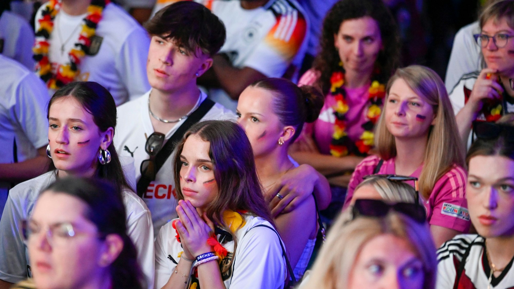 Zu sehen sind Fußballfans in Deutschland-Triktos.