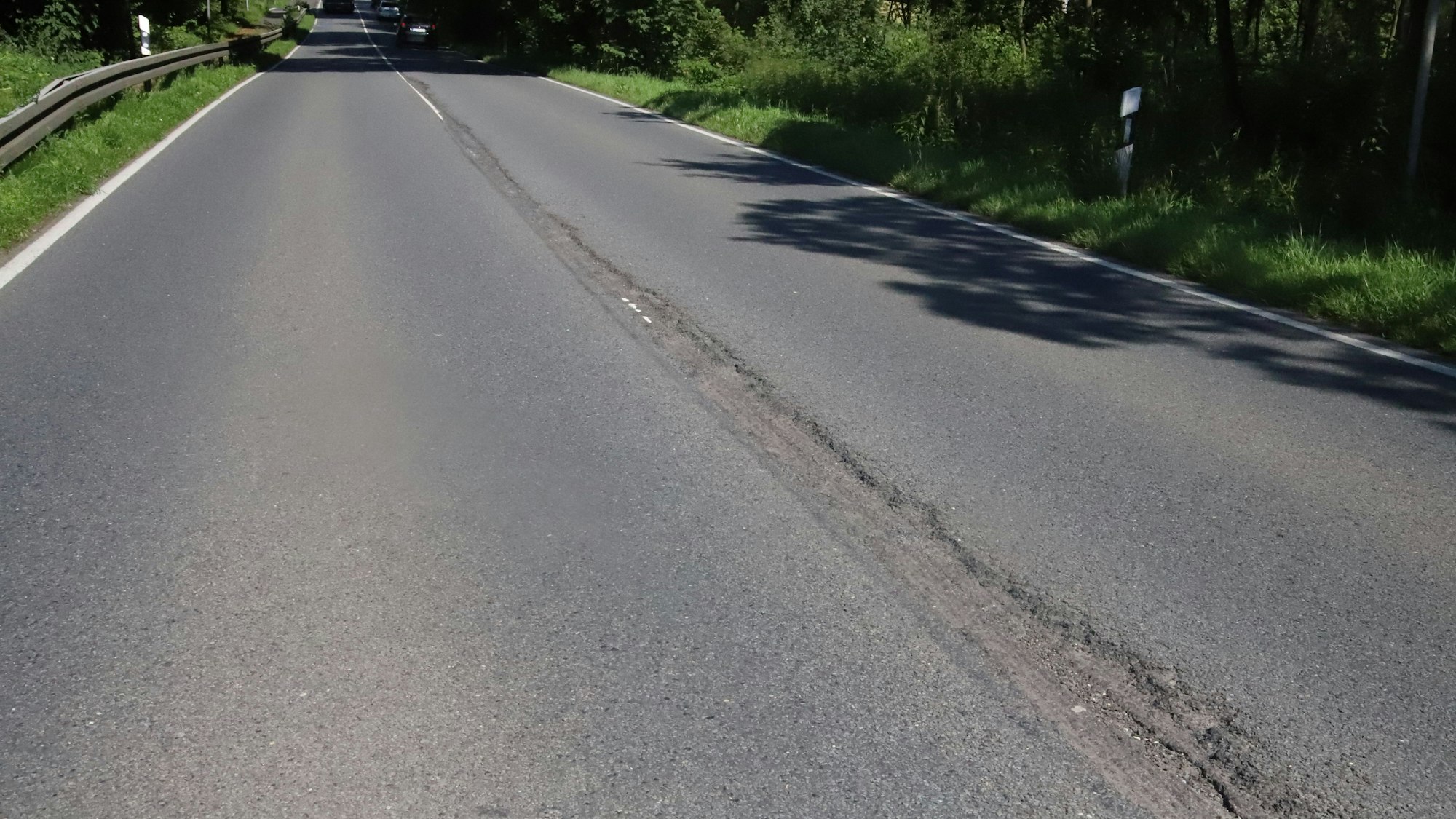 Tiefe Furchen ziehen sich entlang der Mittelnaht der Fahrbahn der Bundesstraße 8.