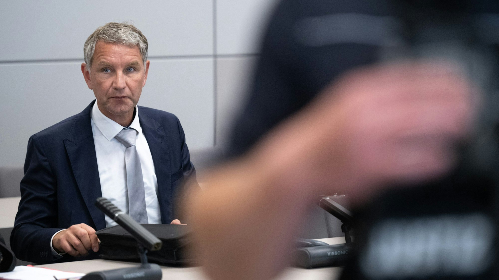 Björn Höcke, Vorsitzender der Thüringer AfD, sitzt nach einer Verhandlungspause im Landgericht Halle/Saale. Höcke muss sich erneut wegen der Verwendung einer verbotenen Losung der Sturmabteilung (SA) verantworten.