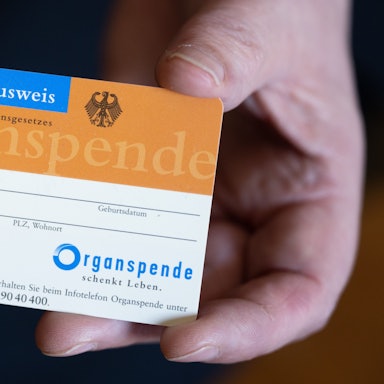 Eine Frau hält einen Organspendeausweis in der Hand.