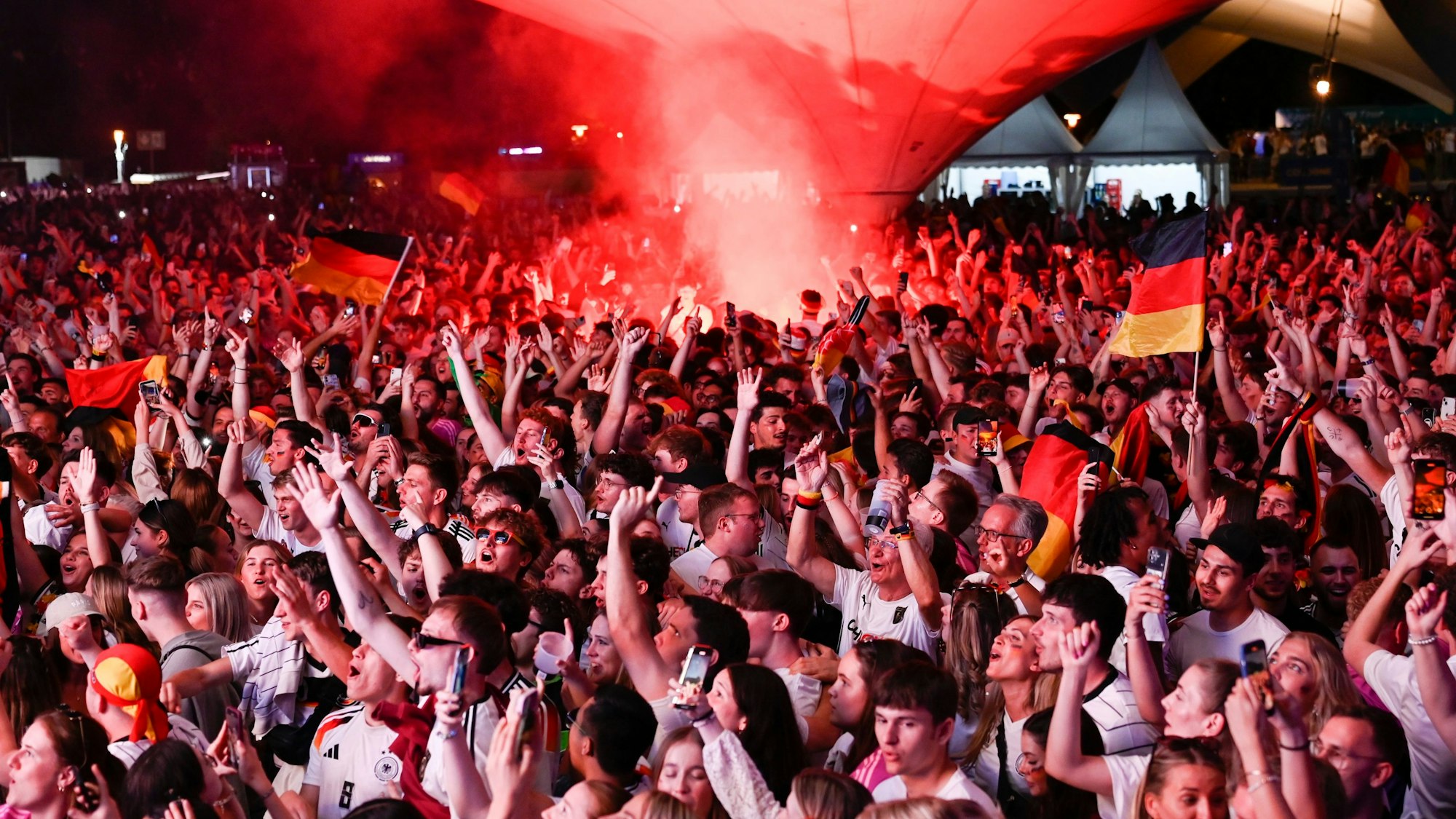 Zu sehen sind feiernde Fußballfans mit Deutschland-Triktos.