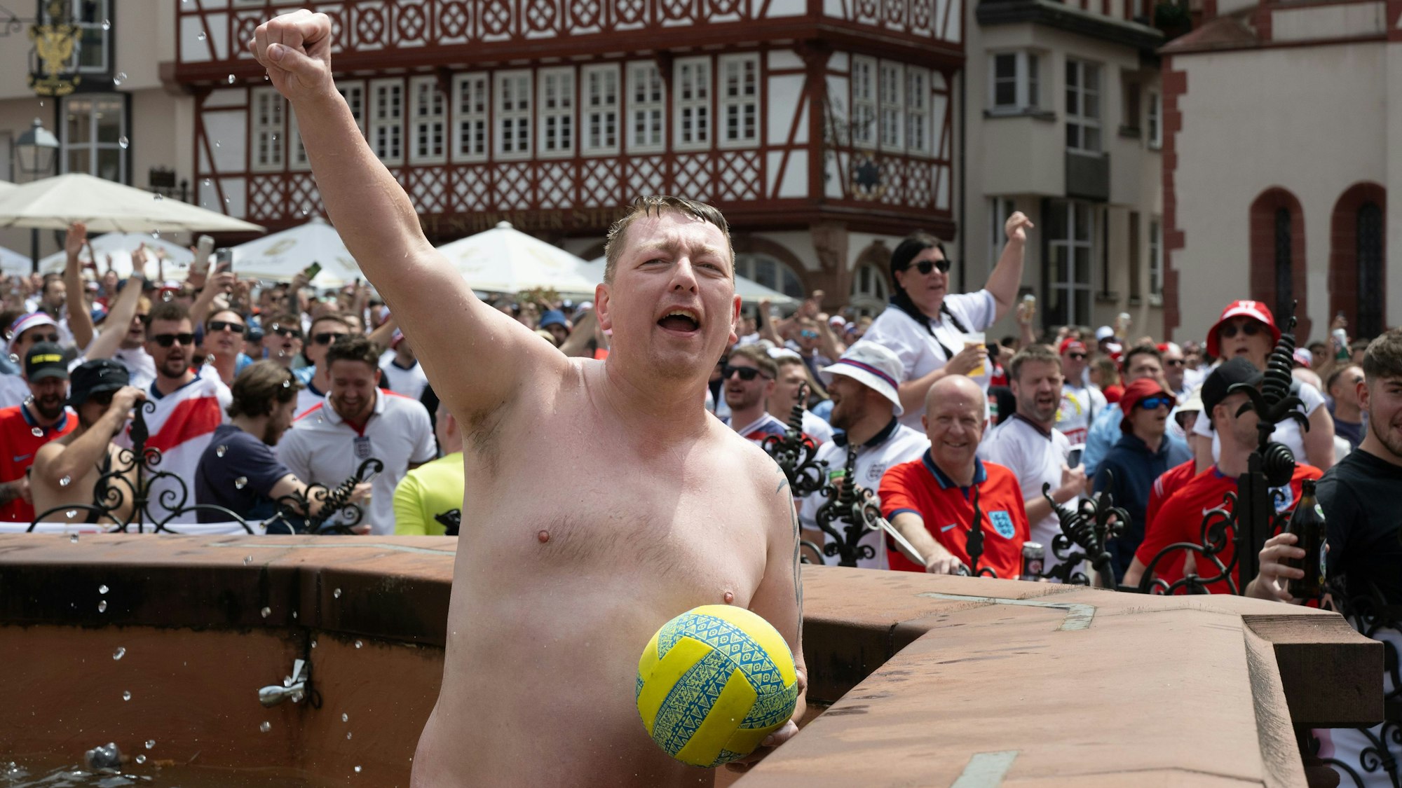 Englische Fans feiern auf dem Römerberg in Frankfurt. Dabei ist ein Mann halb nackt in den Justitia-Brunnen gestiegen.