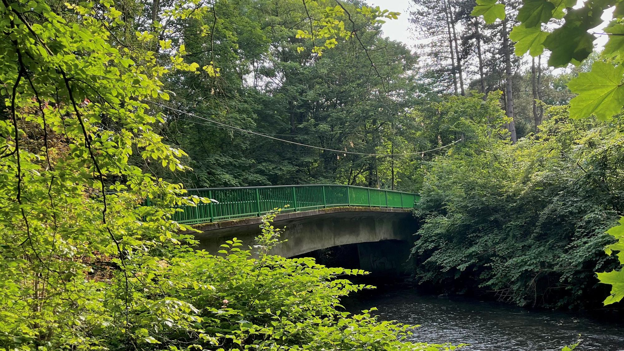 Eine baufällige Brücke überspannt einen Fluss.