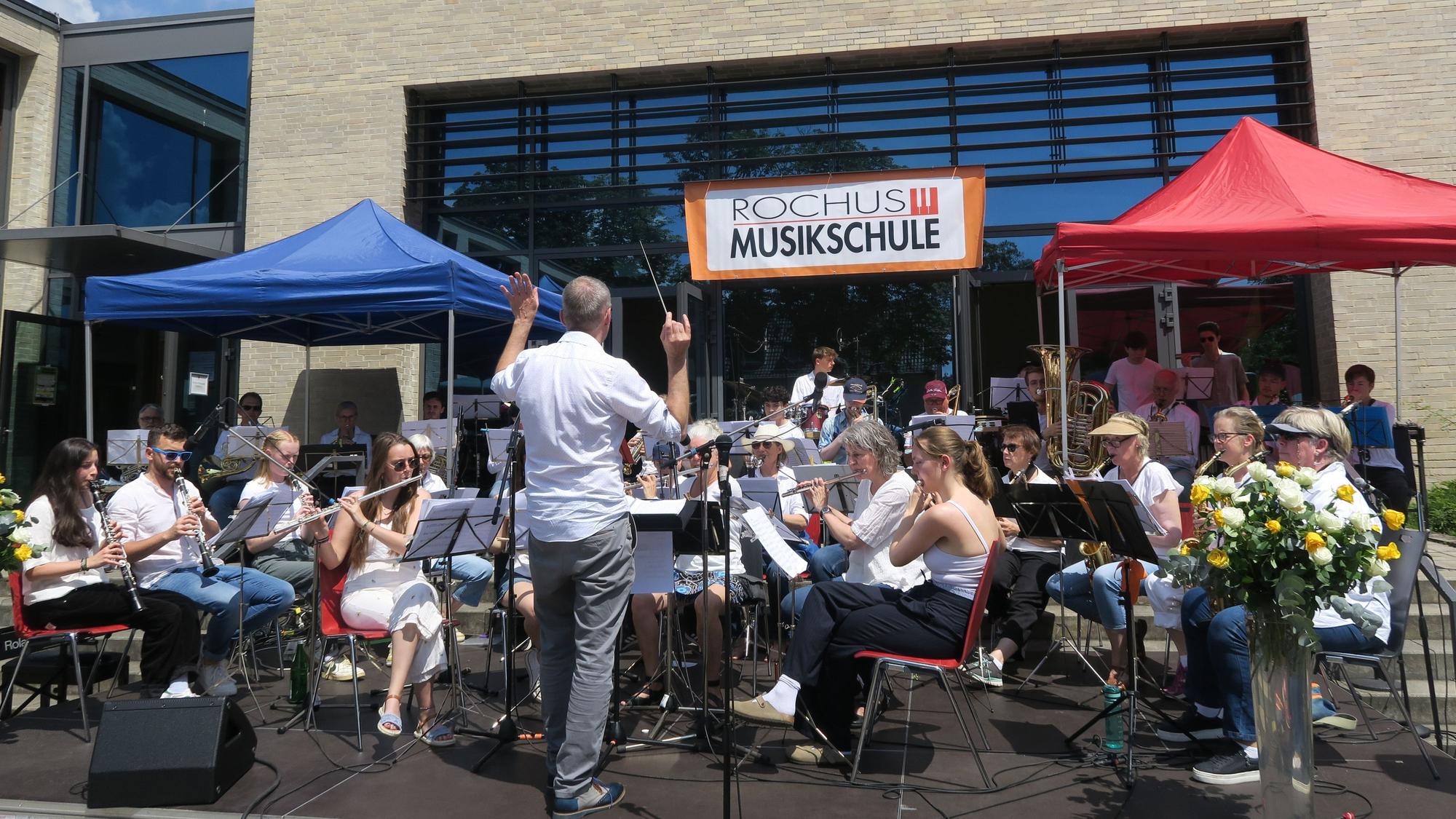 Das Blasorchester der Rochus-Musikschule unter Leitung von Norbert Krämer vor dem Bios Inn.