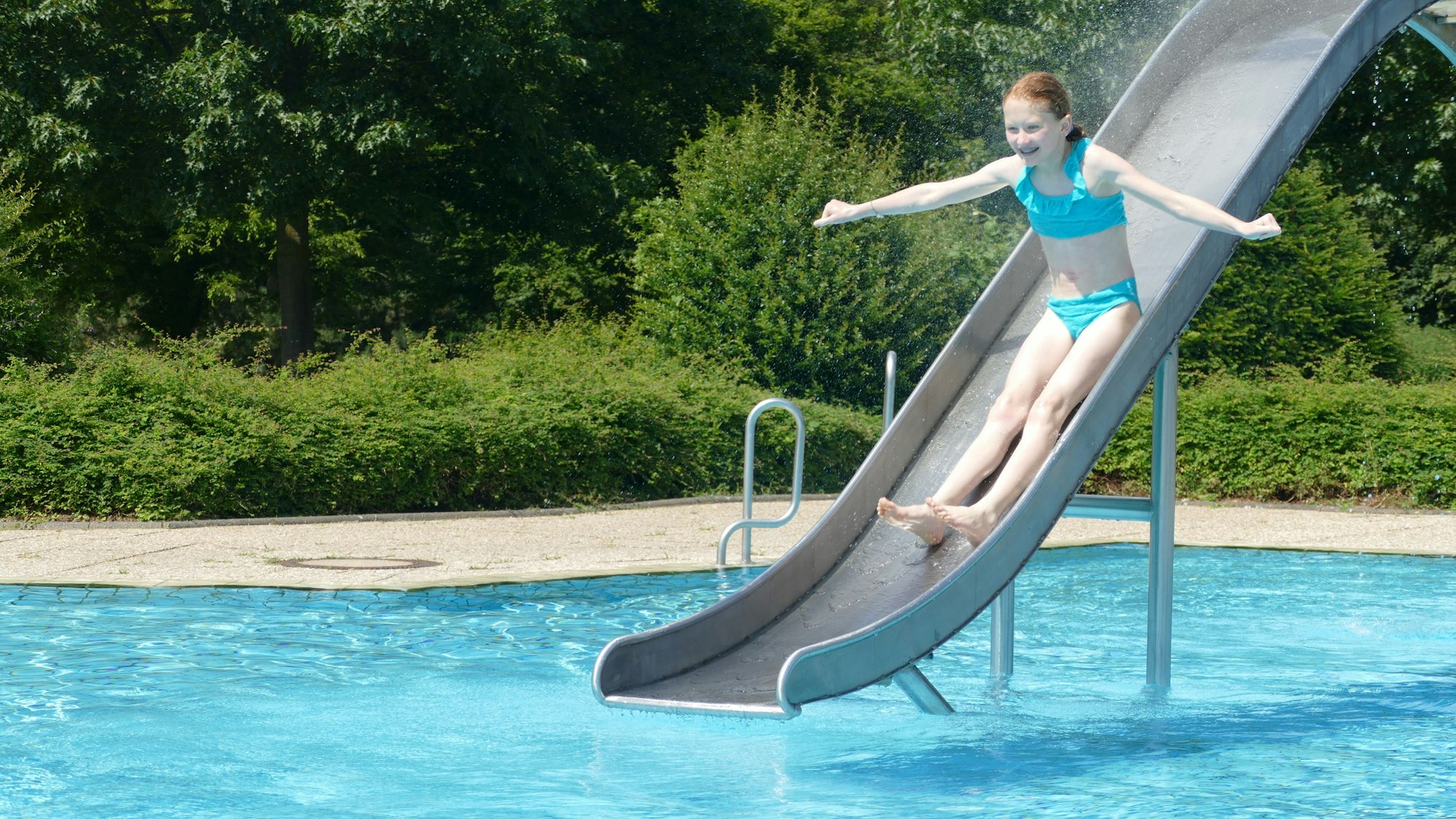 Ein Mädchen rutsche eine Rutsche hinunter.