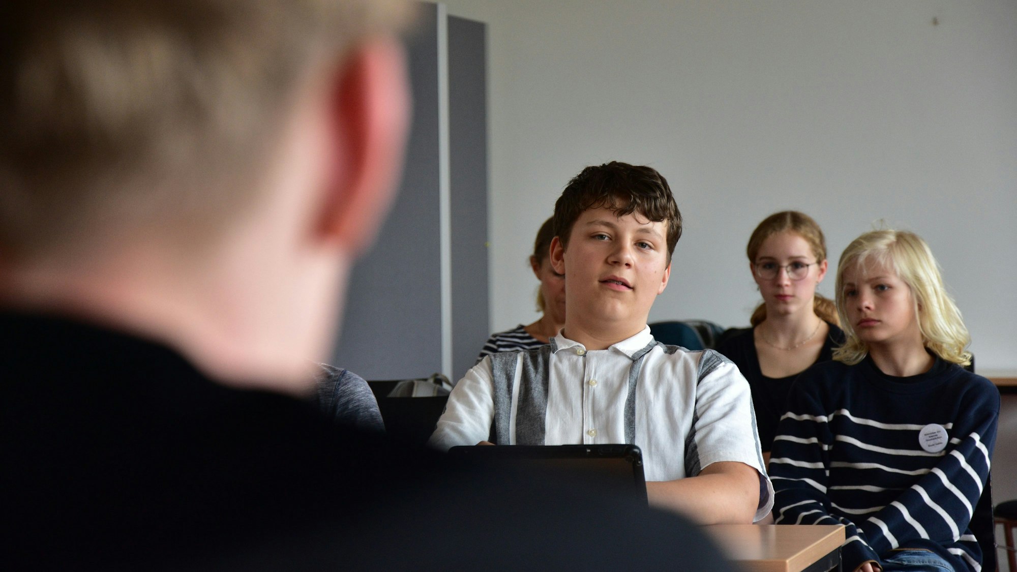 Mehrere Schüler sitzen in einer Klasse.
