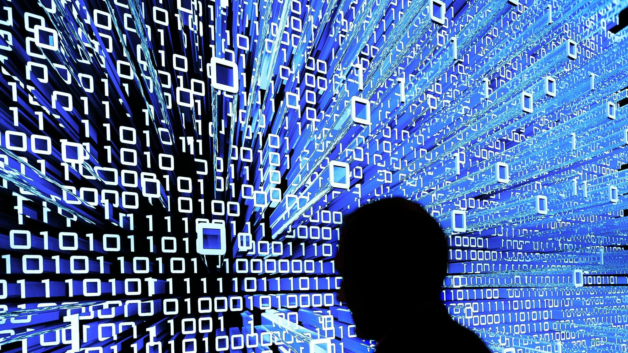 Ein Messebesucher geht an einem Leuchtdisplay auf der CeBIT in Hannover vorbei.