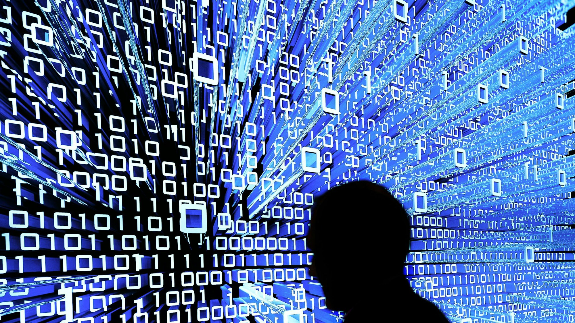 Ein Messebesucher geht an einem Leuchtdisplay auf der CeBIT in Hannover vorbei.