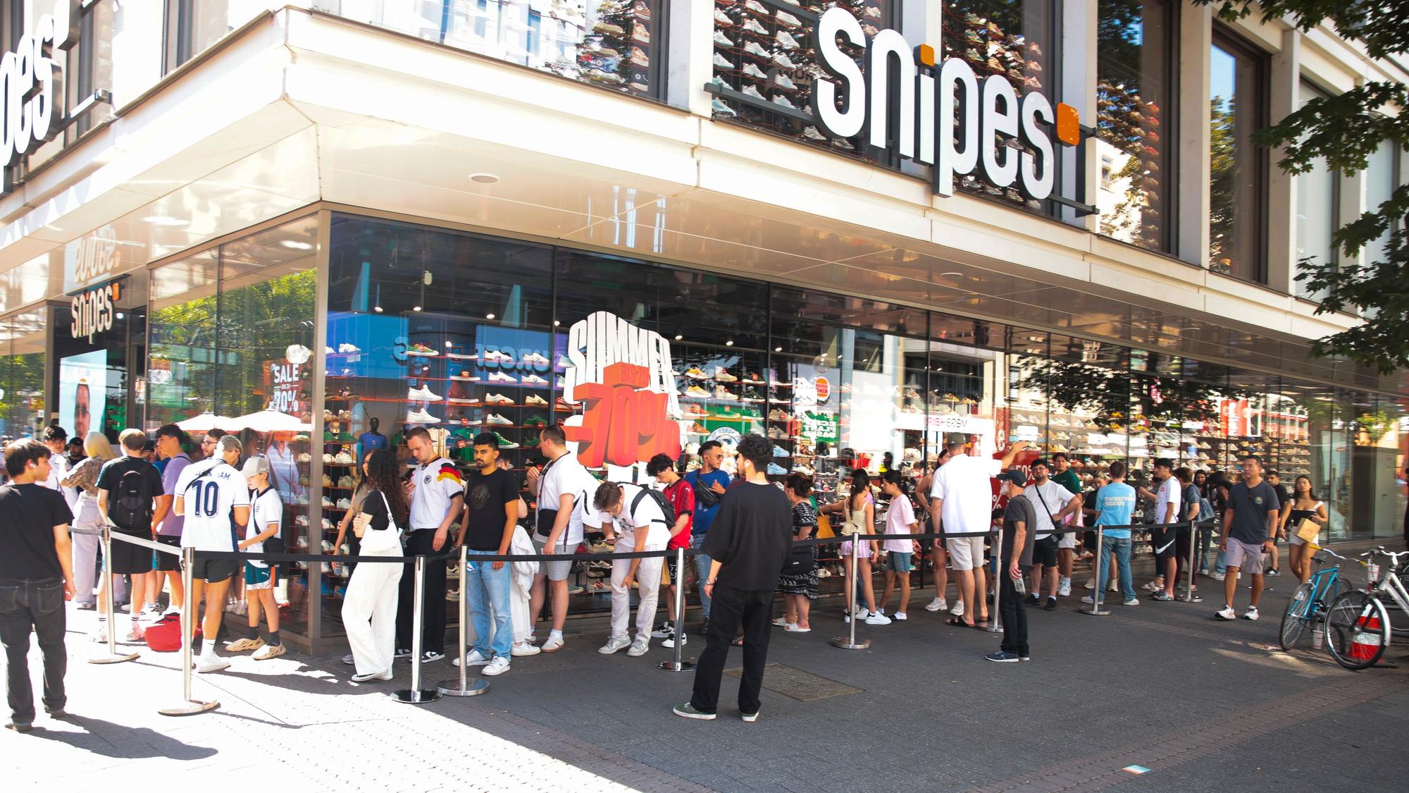 Vor dem Snipes Store auf der Schildergasse steht eine lange Schlange mit jungen Leuten.