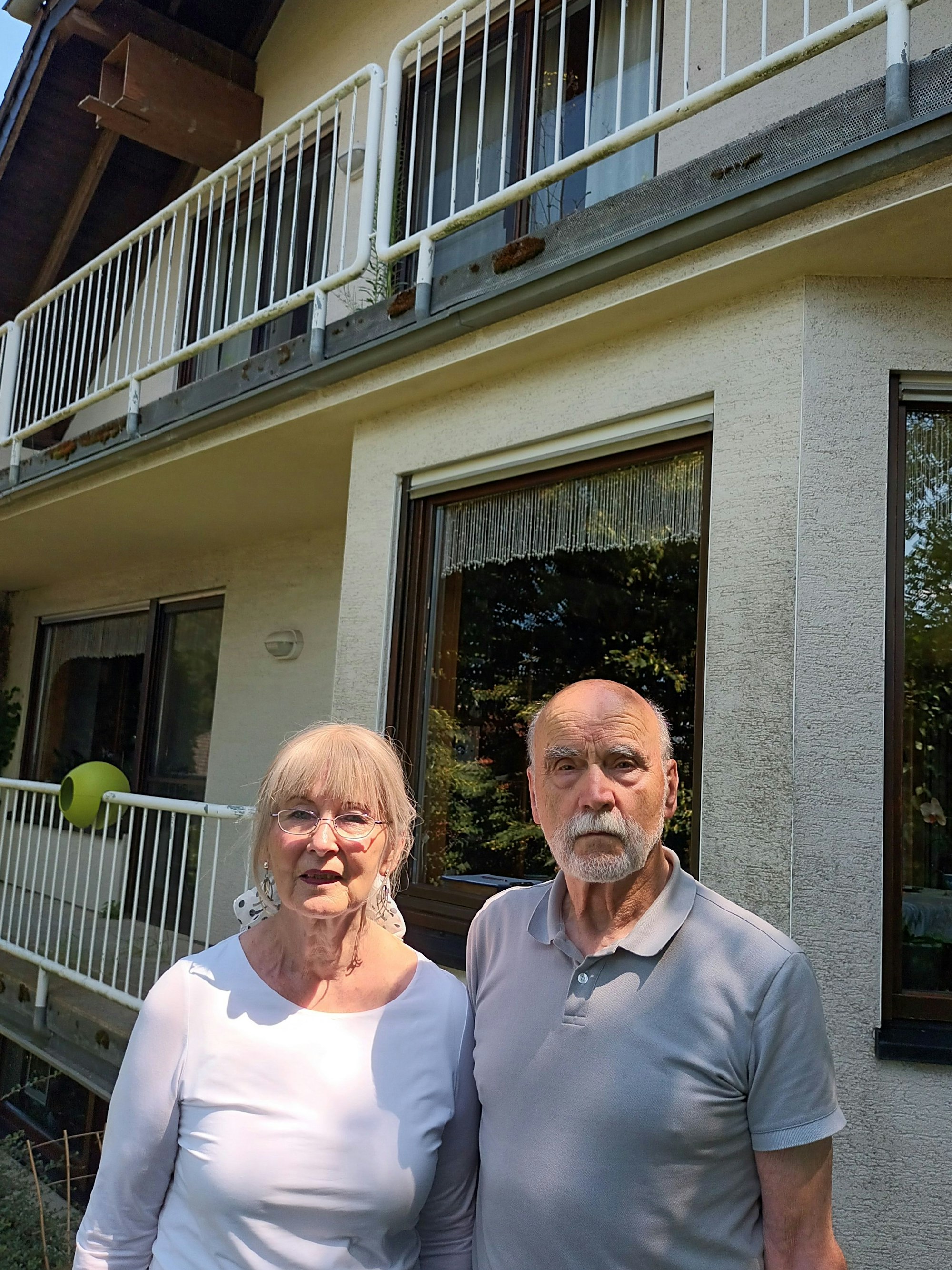 Ein Paar vor seinem Haus, im zweiten Stock ein großer Nistkasten