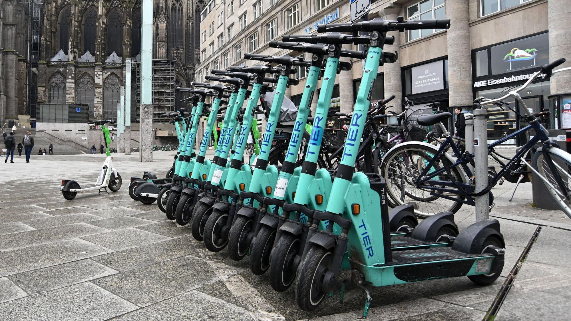 Zu sehen sind mehrere Elektroroller in der Seitenansicht, die am Kölner Hauptbahnhof ordnungsgemäß abgestellt wurden.