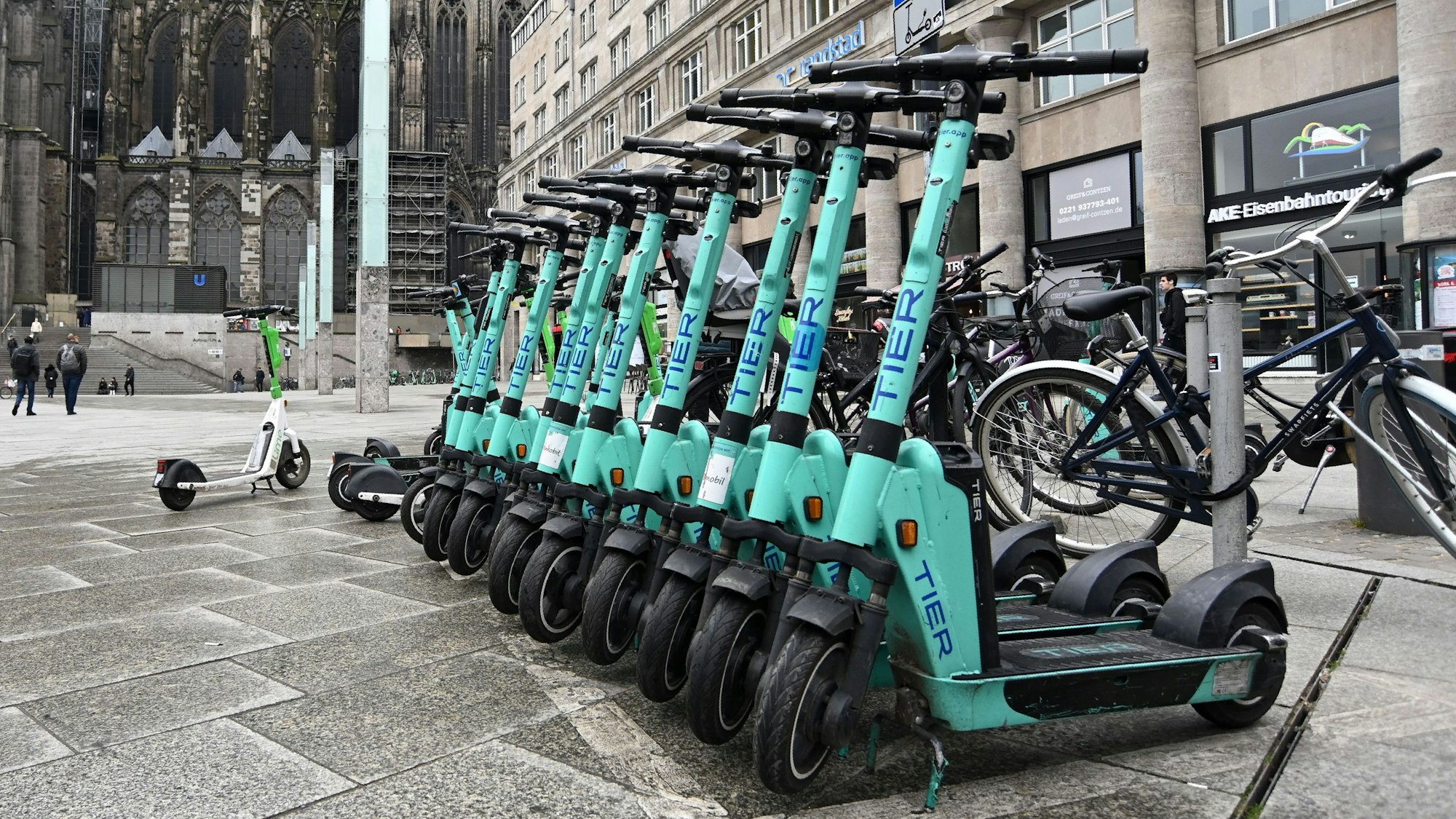 Zu sehen sind mehrere Elektroroller in der Seitenansicht, die am Kölner Hauptbahnhof  ordnungsgemäß abgestellt wurden.