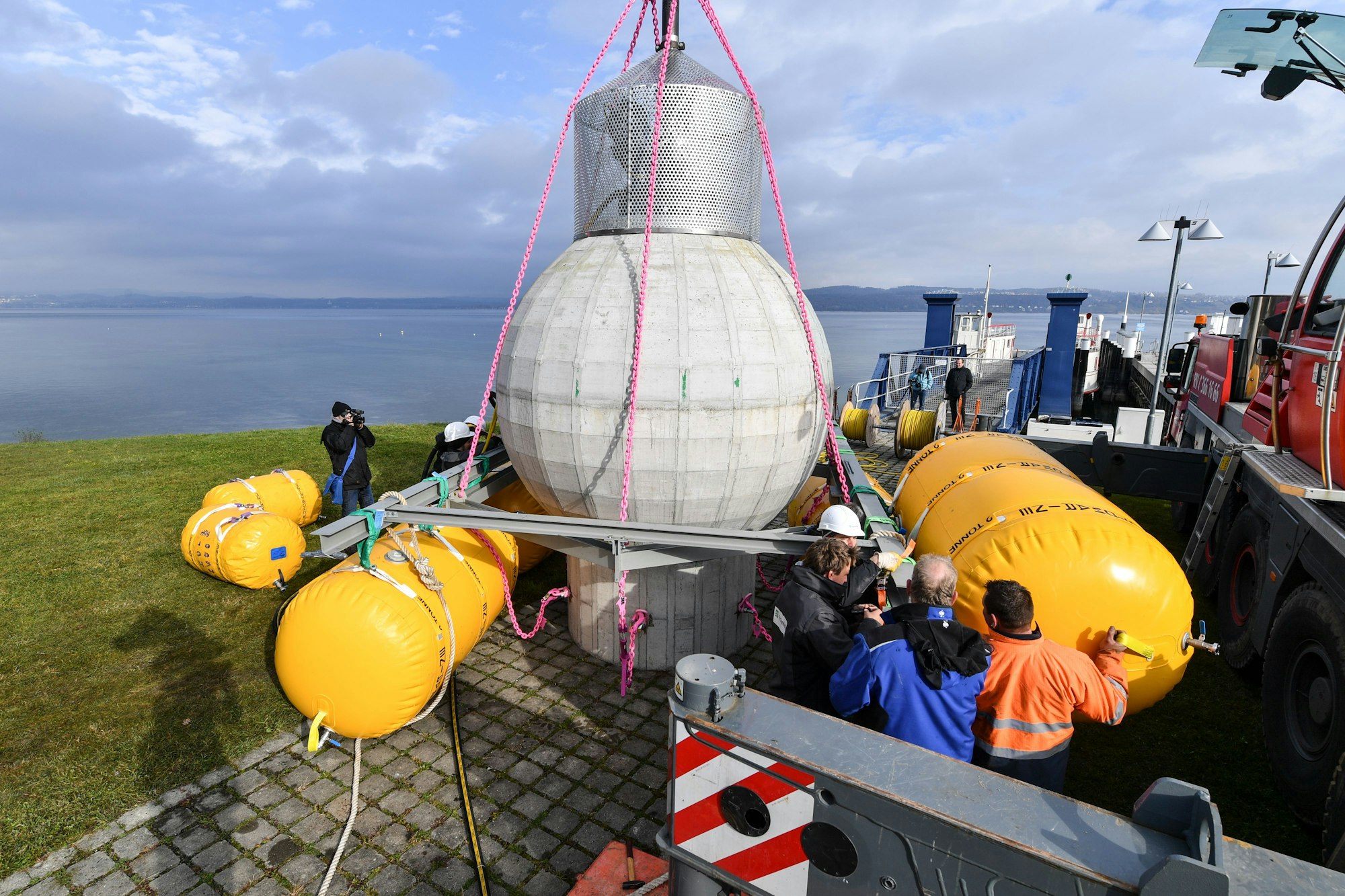 Mitarbeiter des Fraunhofer-Instituts bereiten am 08.11.2016 in Konstanz (Baden-Württemberg) unmittelbar am Ufer des Bodensees einen Kugelspeicher aus Beton vor, um diesen später im Bodensee für wenige Wochen zu Testzwecken zu versenken. Mit der Kugel, die einen Durchmesser von drei Metern hat, soll nach Institutsangaben getestet werden, ob sie unter Wasser als Energiespeicher dienen kann. Foto: Felix Kästle/dpa ++ +++ dpa-Bildfunk +++