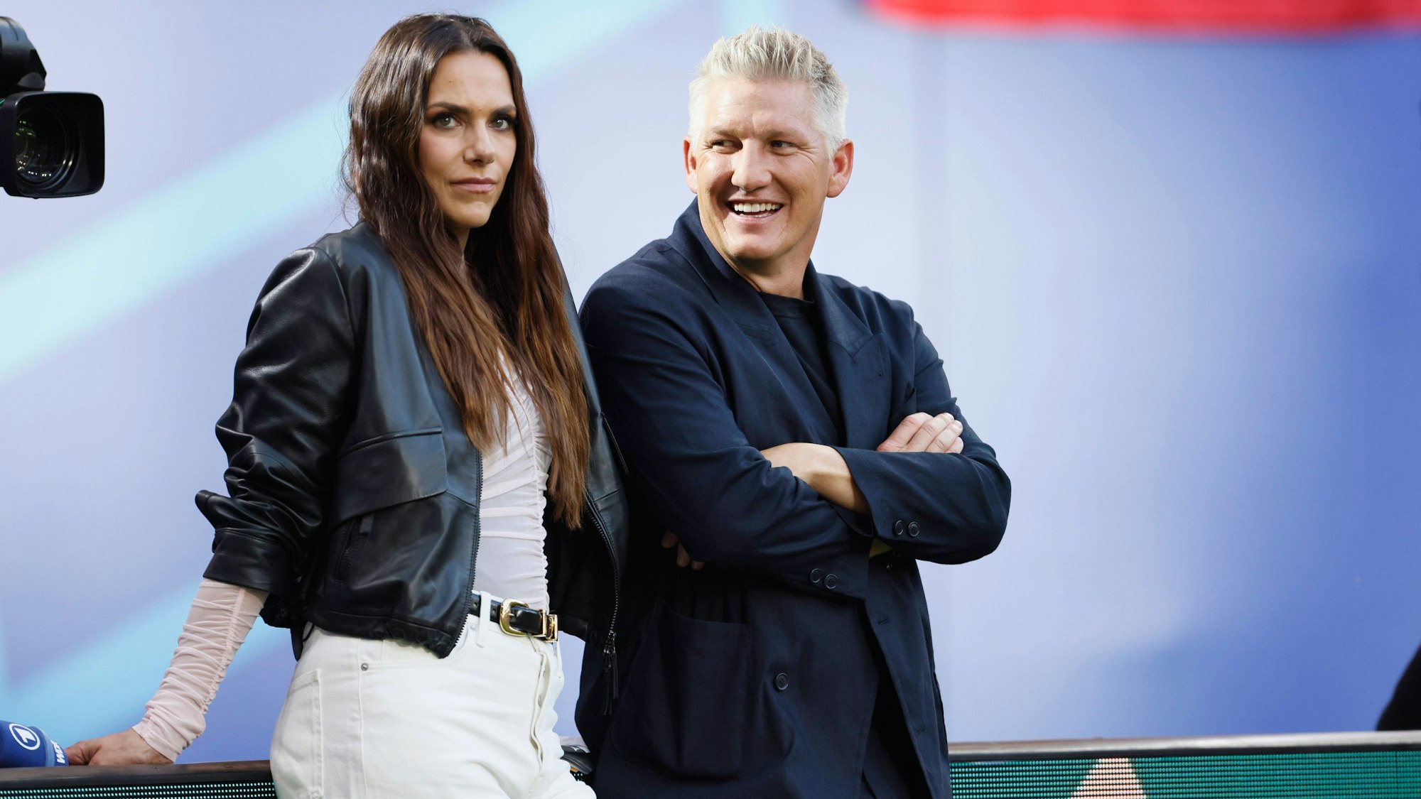 Bastian Schweinsteiger und Esther Sedlaczek stehen am Spielfeldrand.