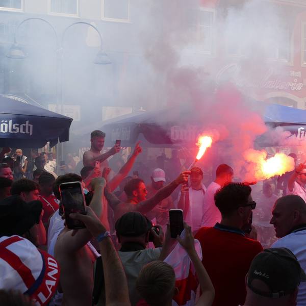 Zu sehen sind Fußballfans mit Rauchbomben und Bengalos.