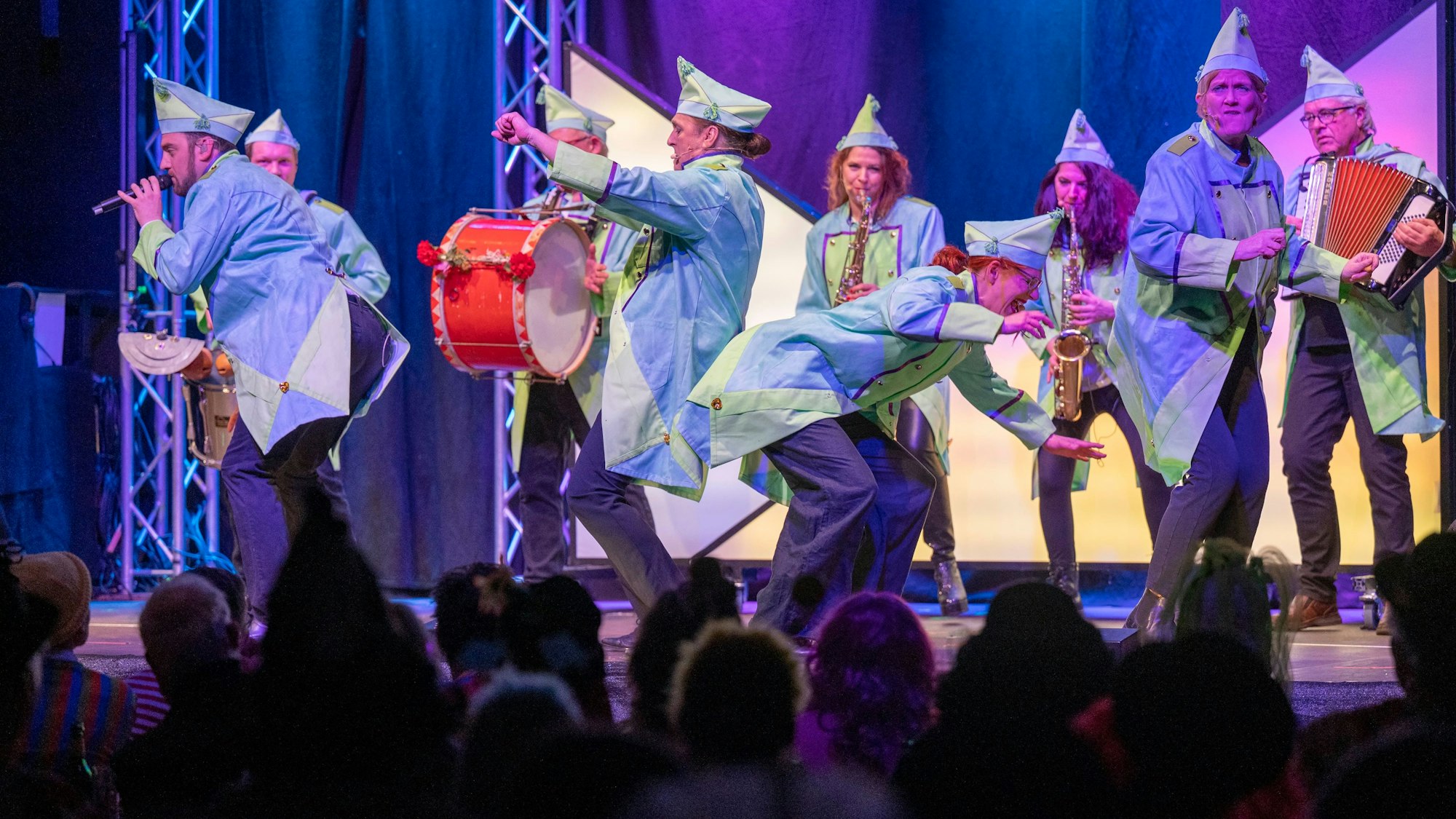 Menschen spielen in Uniform auf der Bühne Instrumente.