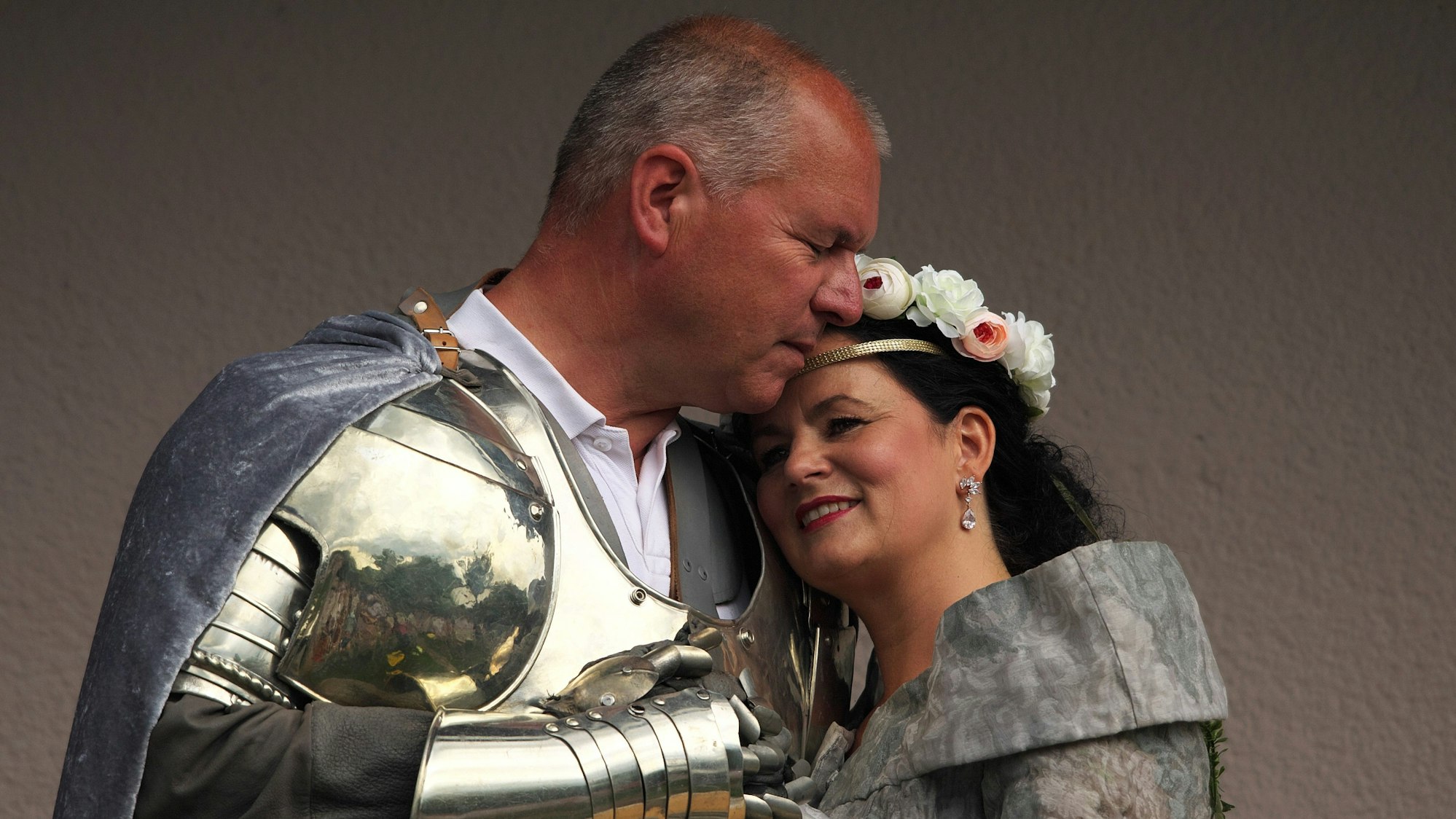 Sabine Vinke lehnt sich an Stefan Vinkes Brust. Stefan Winke trägt einen Plattenpanzer und einen Umhang. Sabine Vinke trägt ein Blumendiadem.