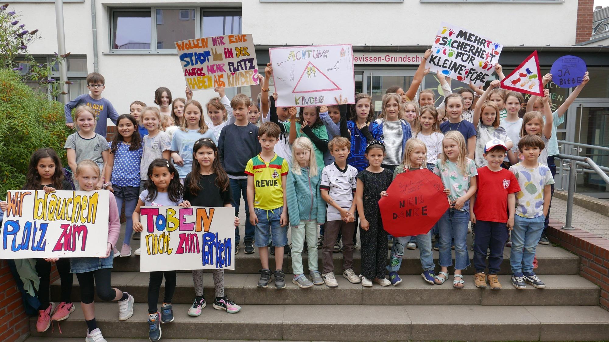Kinder der Mathilden-von-Mevissen-Grundschule demonstrieren anlässlich des Fußverkehrs-Checks für mehr Sicherheit im Umkreis ihrer Schule.