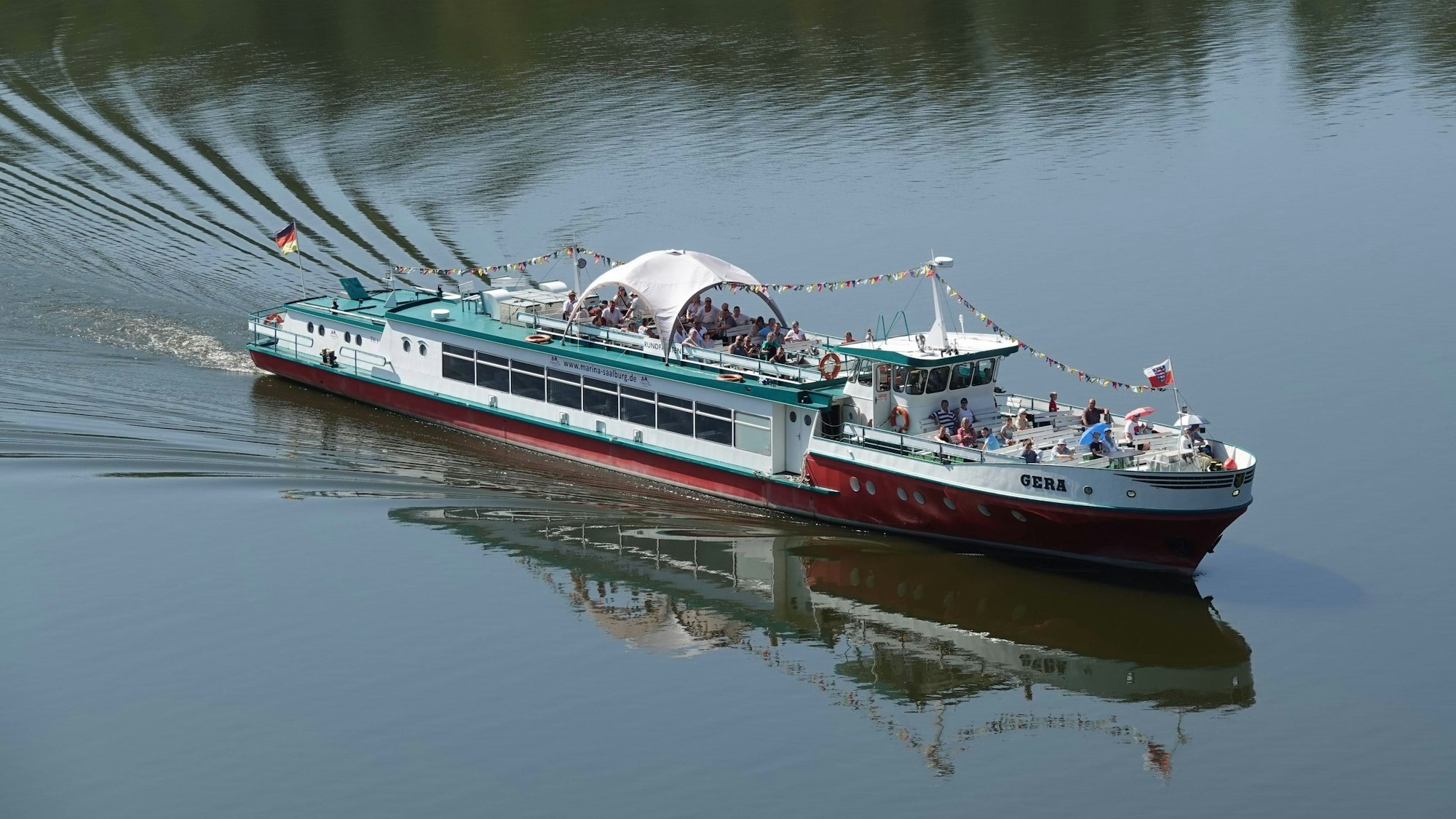 Mehrzweckschiff Gera mit Spiegelung im Wasser bei Fahrt auf Bleilochtalsperre Dieses Foto zeigt das Mahrzweckschiff Gera wÄhrend einer Fahrt auf der Bleilochtalsperre größte talsperre Deutshlands. Durch das ruhige Wasser ohne Wellen spiegelt sich das Schiff. Copyright: xZoonar.com/FlorianxWildx 16425987