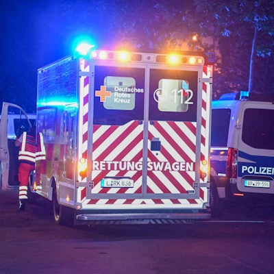Ein Krankenwagen und ein Einsatzwagen der Polizei stehen mit Blaulicht auf einer Straße während eines Einsatzes. (Symbolbild)