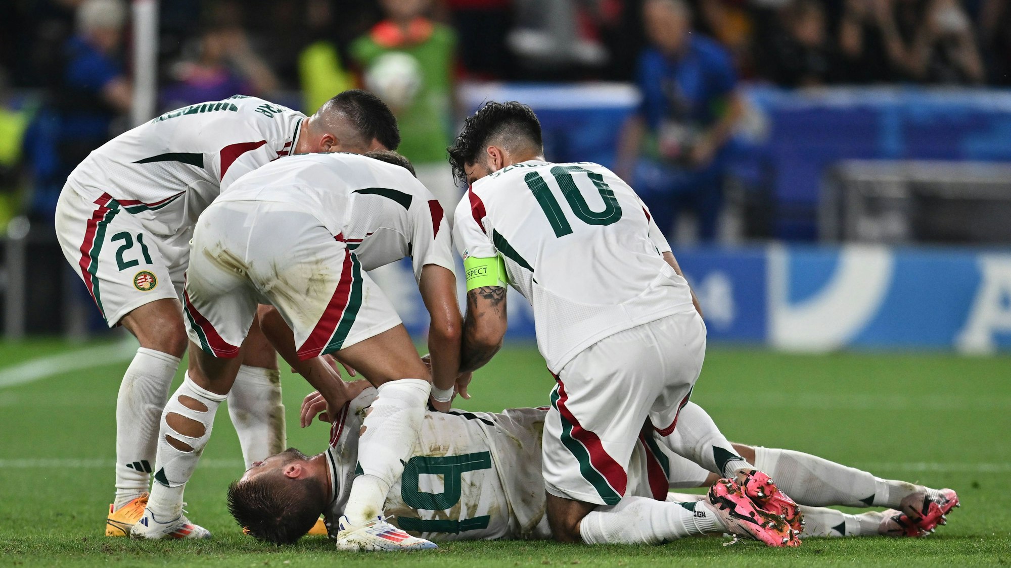 Ungarns Stürmer Barnabas Varga liegt im Spiel gegen Schottland schwer verletzt am Boden. Mitspieler eilen zur Hilfe.