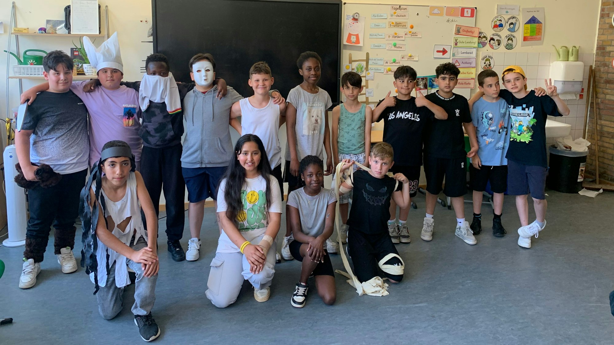 Jungen und Mädchen posieren als Gruppe in einem Klassenraum.
