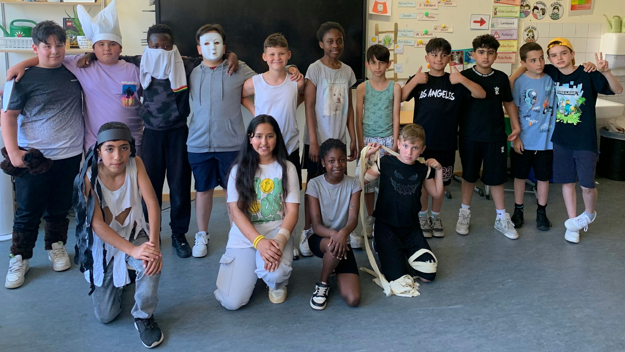 Grundschüler stehen und knien in einem Klassenraum.