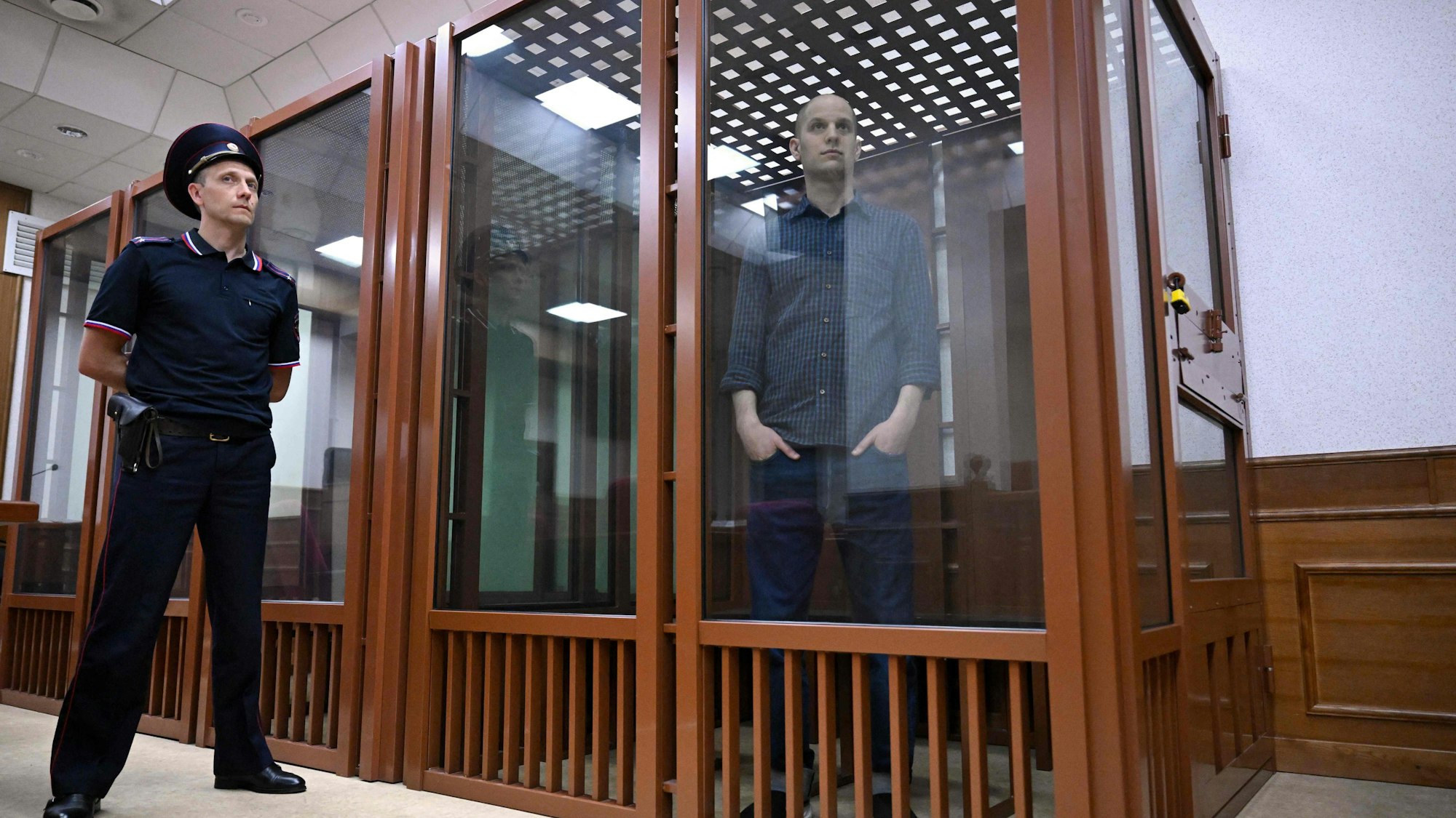 Evan Gershkovich schaut aus einem gesicherten „Glaskasten“.