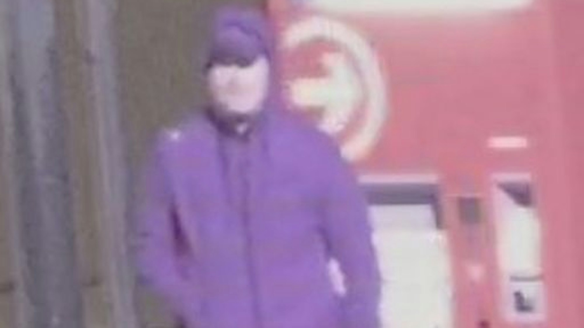 Ein Mann in einem blauen Jogginganzug, Cap, Kapuze und schwarzen Schuhen
