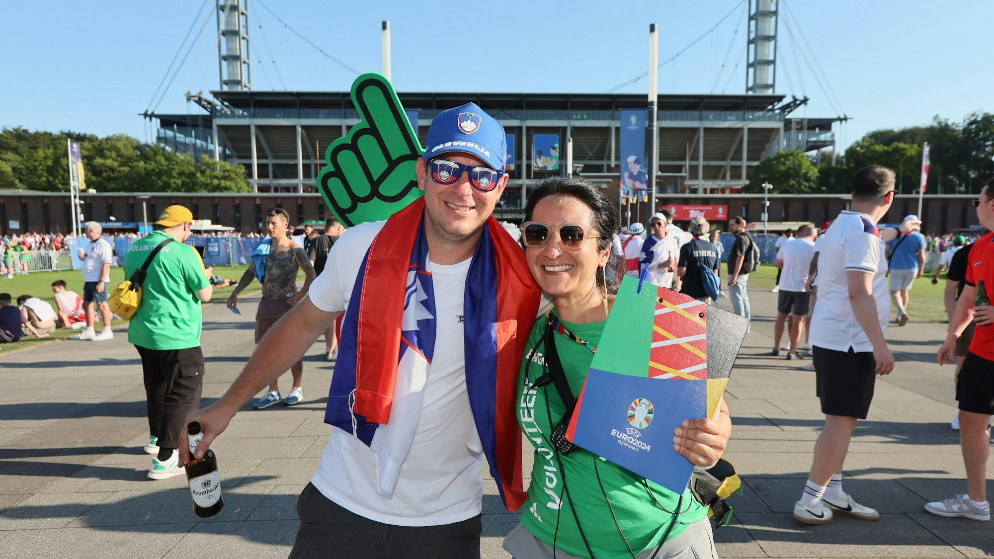 Volunteer Sophia Papageorgiou steht mit einem slowenischen Fan vor dem Stadion in Köln