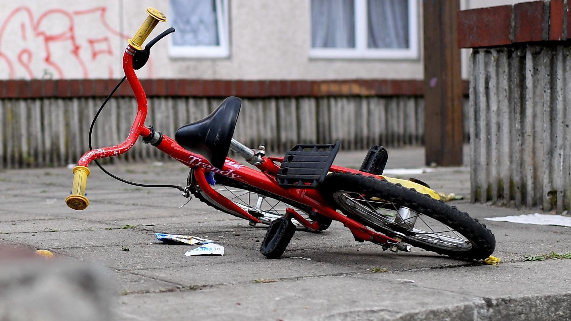 Ein Kinderfahrrad liegt in einem Aufgang zu einem Plattenbau.