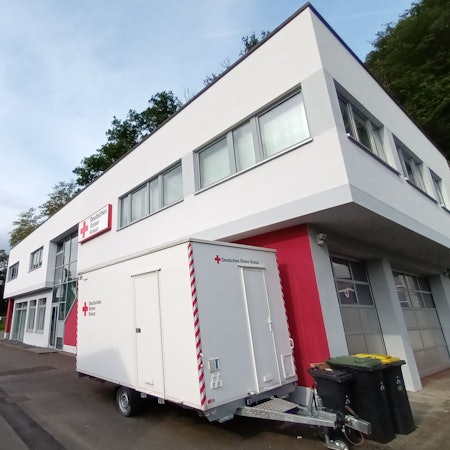 Ein weißes Gebäude mit Logo des Deutschen Roten Kreuzes.