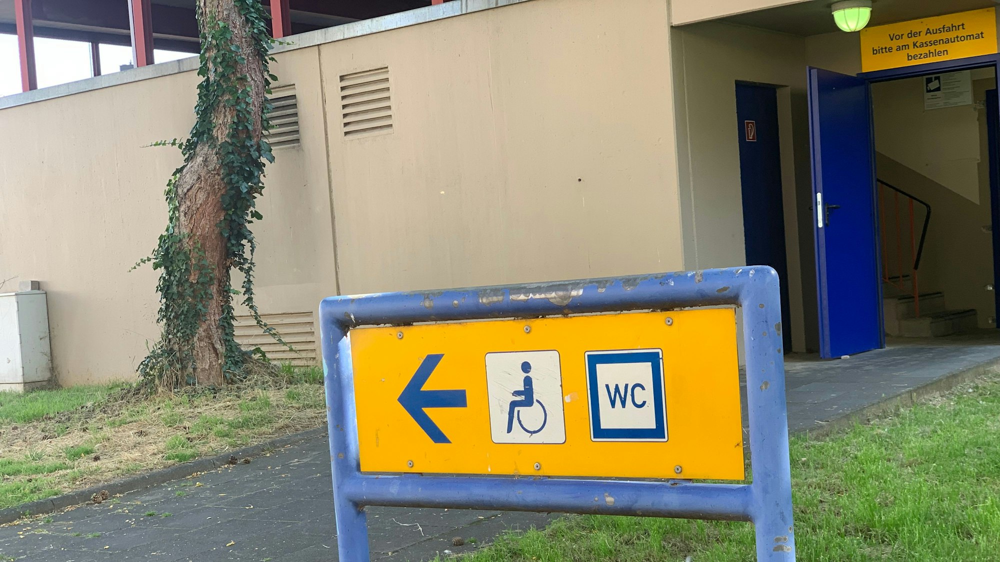 Vor dem Parkhaus Entenpfuhl steht ein Schild, das den Weg zur WC-Anlage weist.