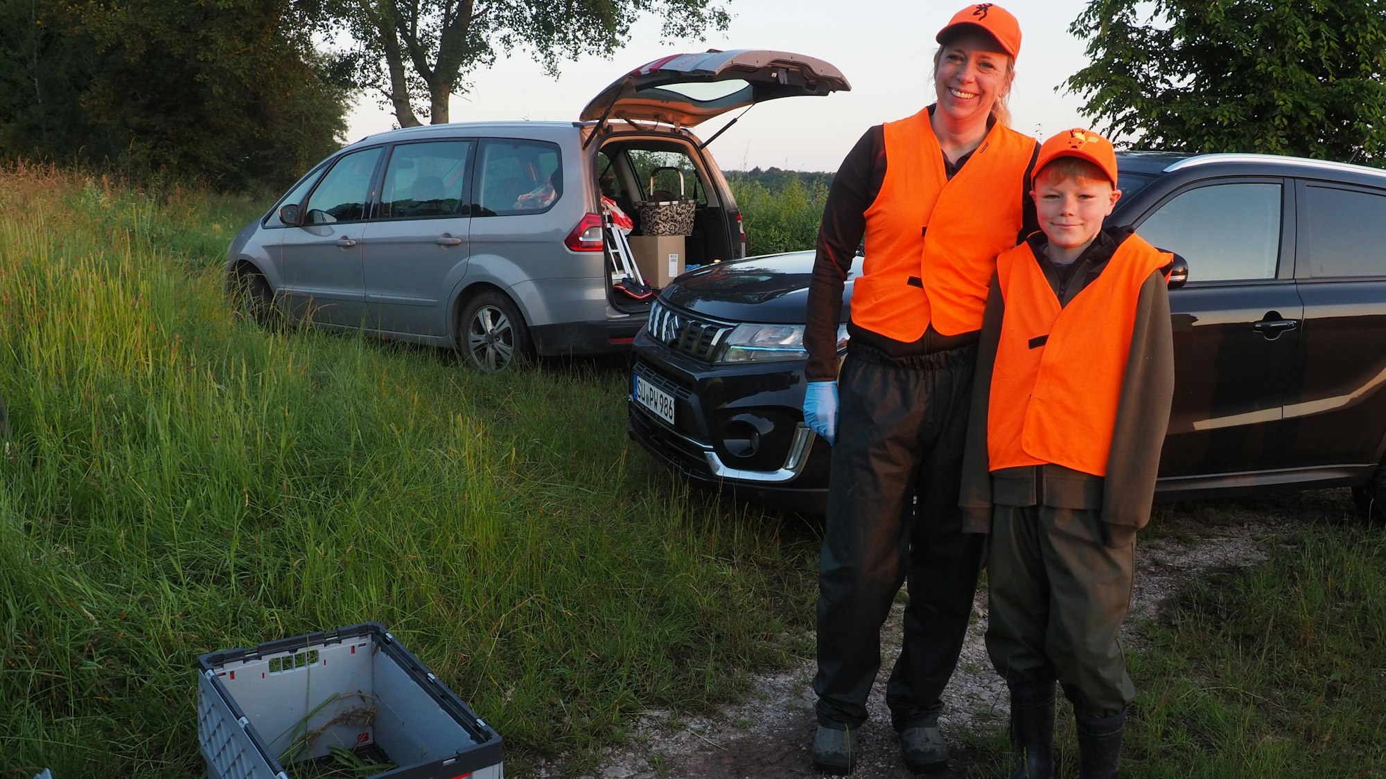 Carina Schneider und ihr Sohn Noah stehen neben den Klappboxen für die Kitze.