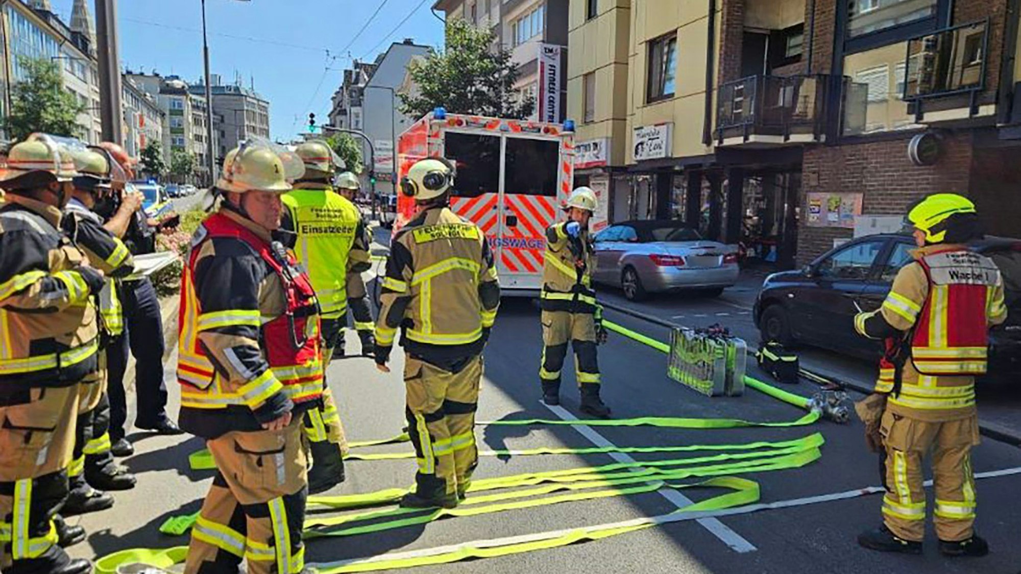 Einsatzkräfte der Feuerwehr und Polizei stehen in Solingen auf der Straße.