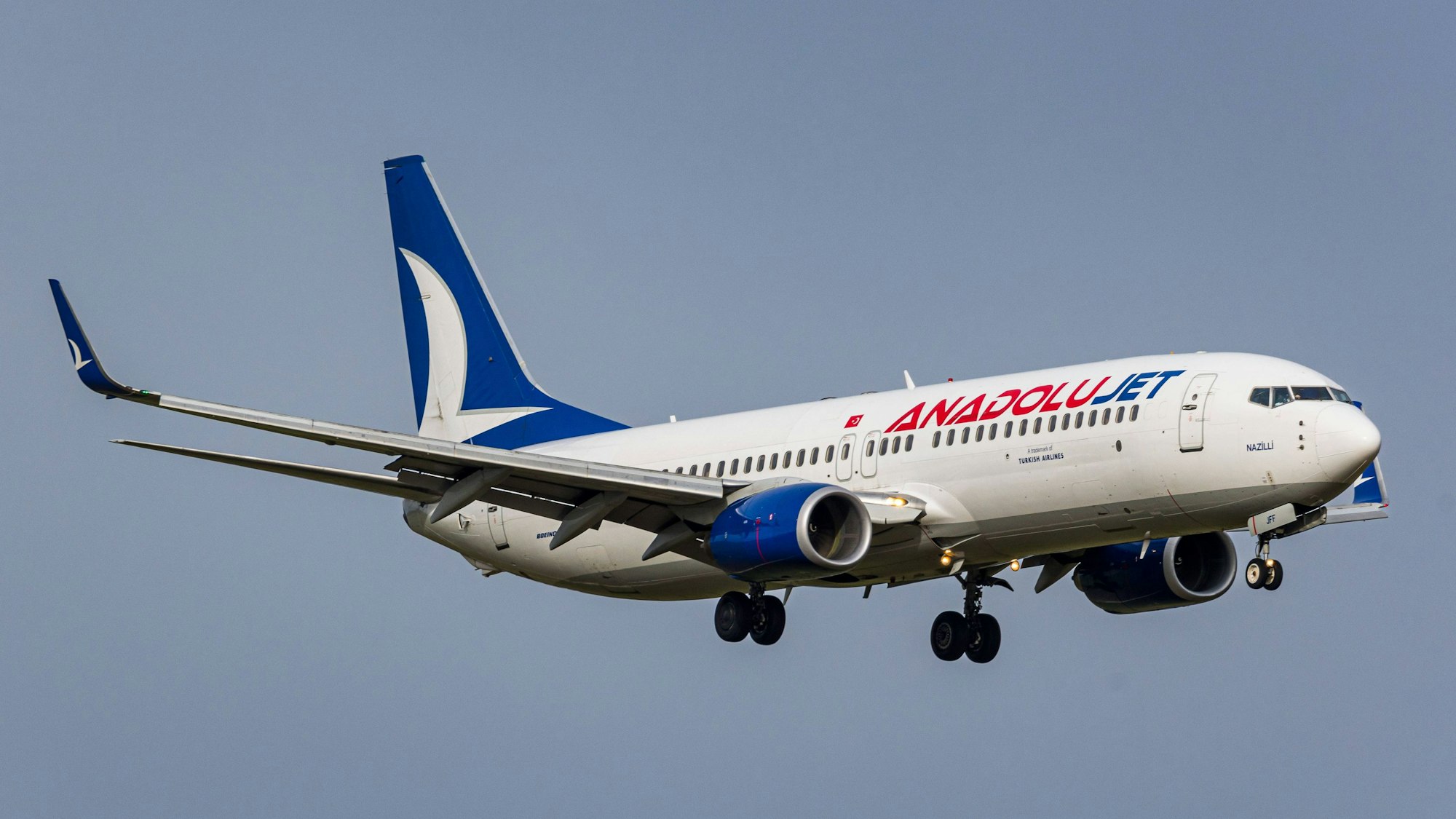 Eine Boeing 737 der türkischen Fluggesellschaft AnadoluJet im Landeanflug vor einem grauen Himmel. (Symbolbild)