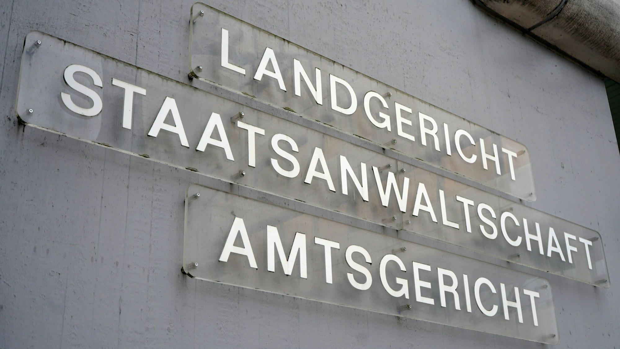 An einem Gebäudekomplex in der Innenstadt von Siegen hängen Schilder, die auf den Sitz des Amtsgerichts, Landgerichts und der Staatsanwaltschaft hinweisen. (Archivbild)