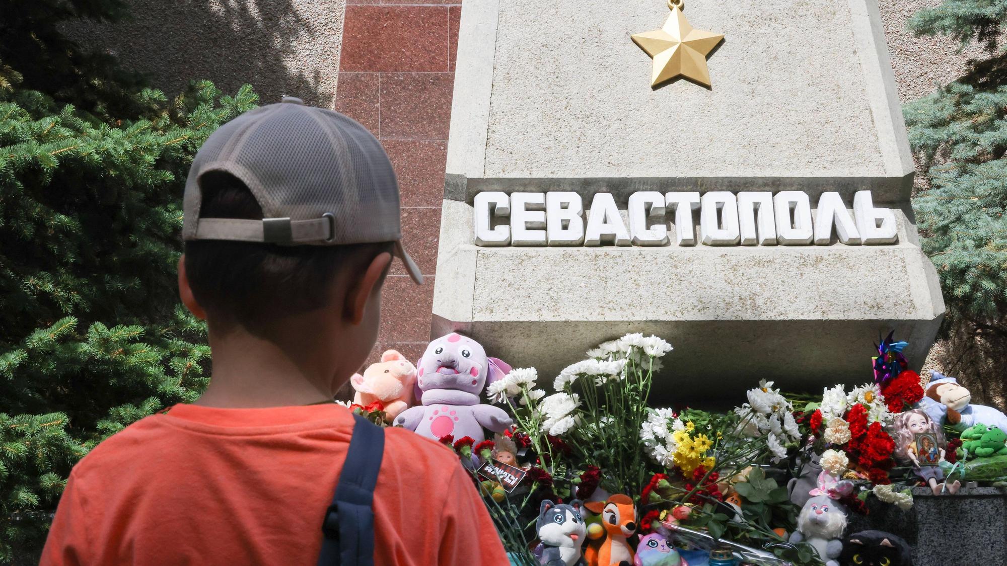Ein russischer Junge steht vor einem provisorischen Denkmal in Sewastopol. Bisher gibt es keinerlei Anzeichen für einen gezielten ukrainischen Beschuss des Strandes auf der Krim.