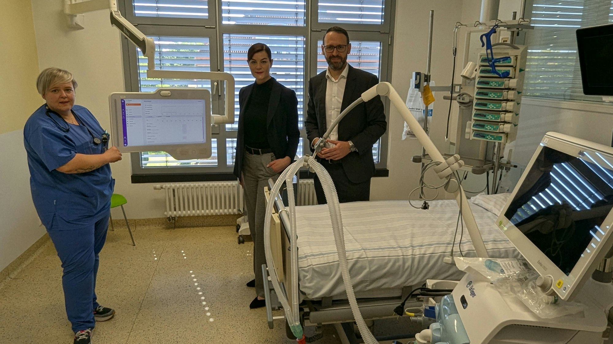 Mitarbeitende des Sana-Krankenhauses in einem Krankenzimmer mit vielen technischen Geräten auf der Intensivstation.