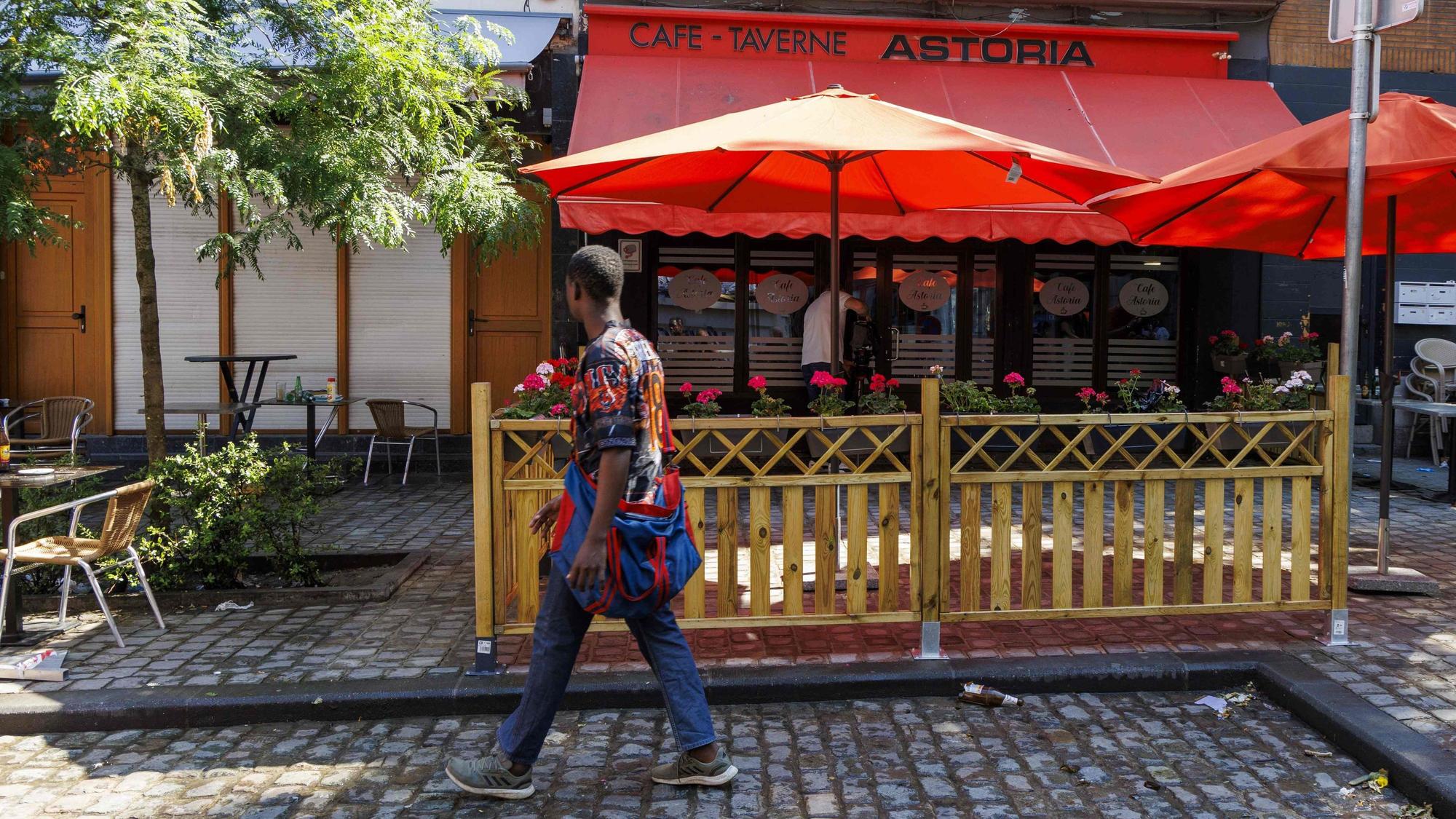 Diese Gesamtansicht zeigt einen Fußgänger, der am 27. Juni 2024 am Tatort einer Schießerei in einer Bar in Saint-Gilles, Brüssel, vorbeigeht. In der Bar in der Nähe des Bahnhofs Brüssel Midi wurden zwei Männer getötet und drei weitere schwer verletzt.