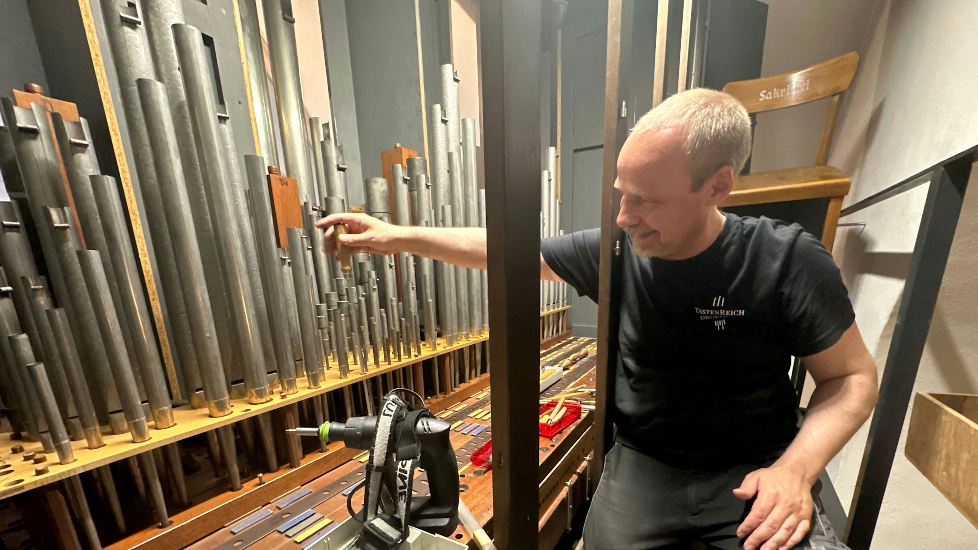 Orgelbauer Wilfried Menne im Inneren des Instrumentes.