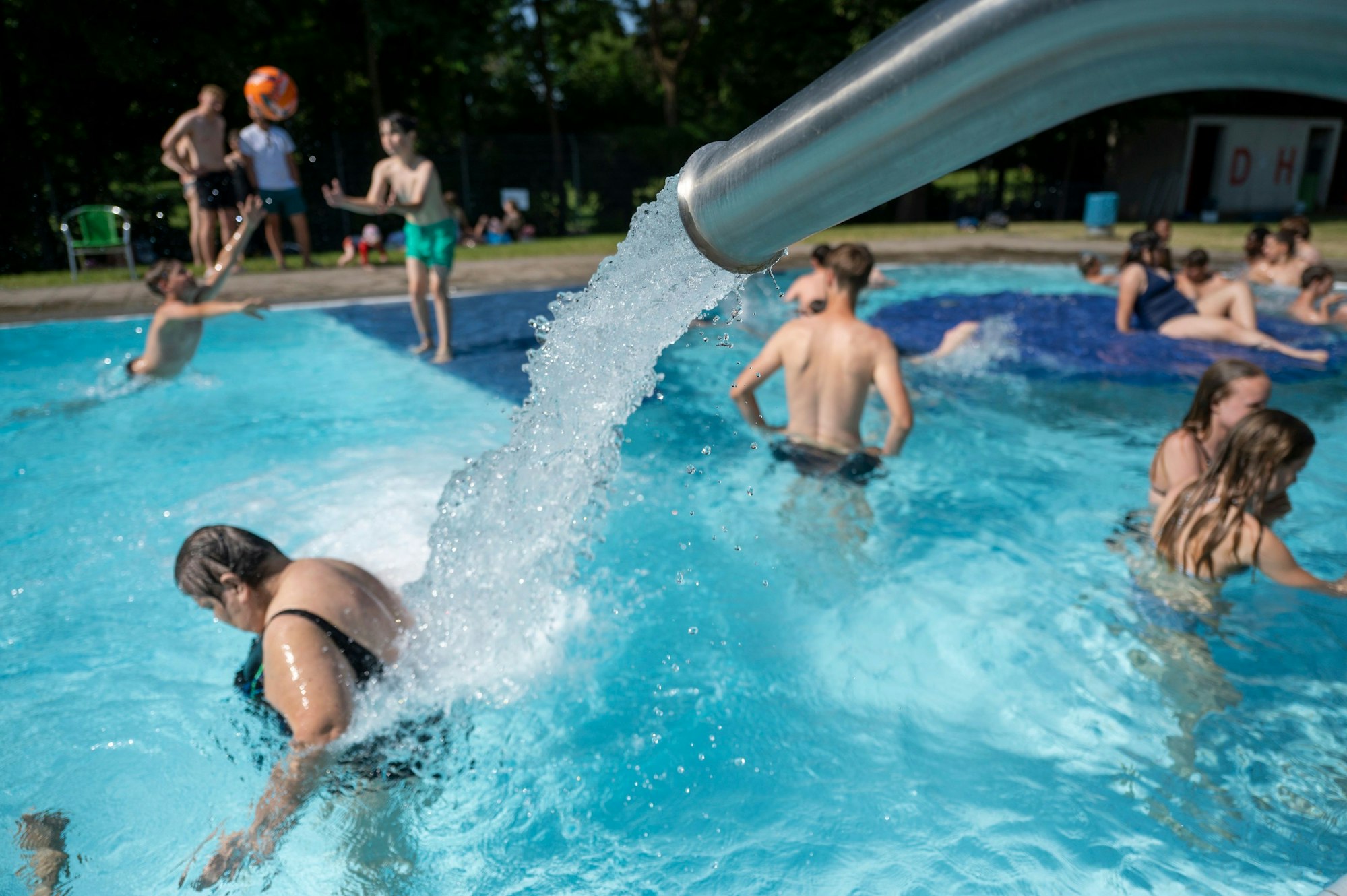 Das Freibad Ossendorf: Im Spaßbecken spielen Kinder Ball, Erwachsene genießen die Massagedüse.