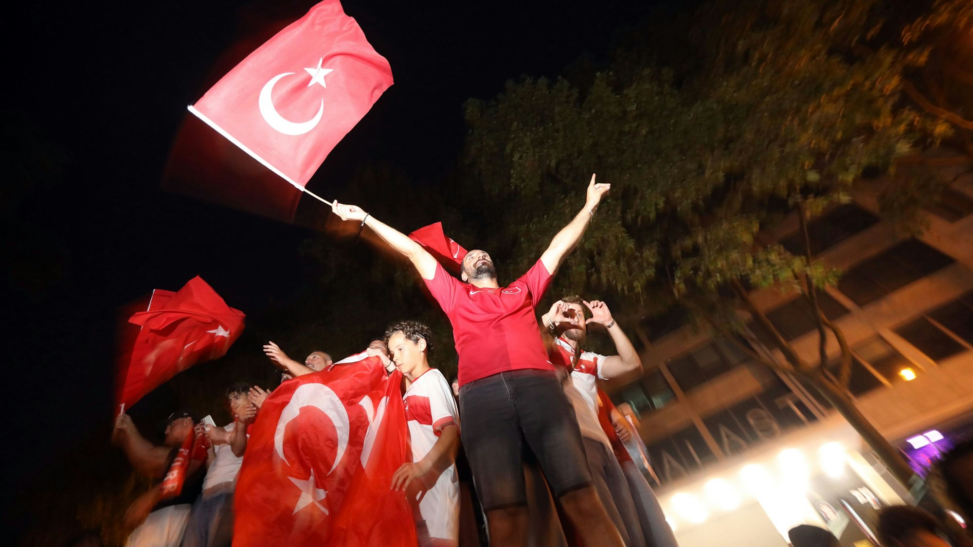 Fans der türkischen Nationalmannschaft feiern ihr Team auf den Ringen.