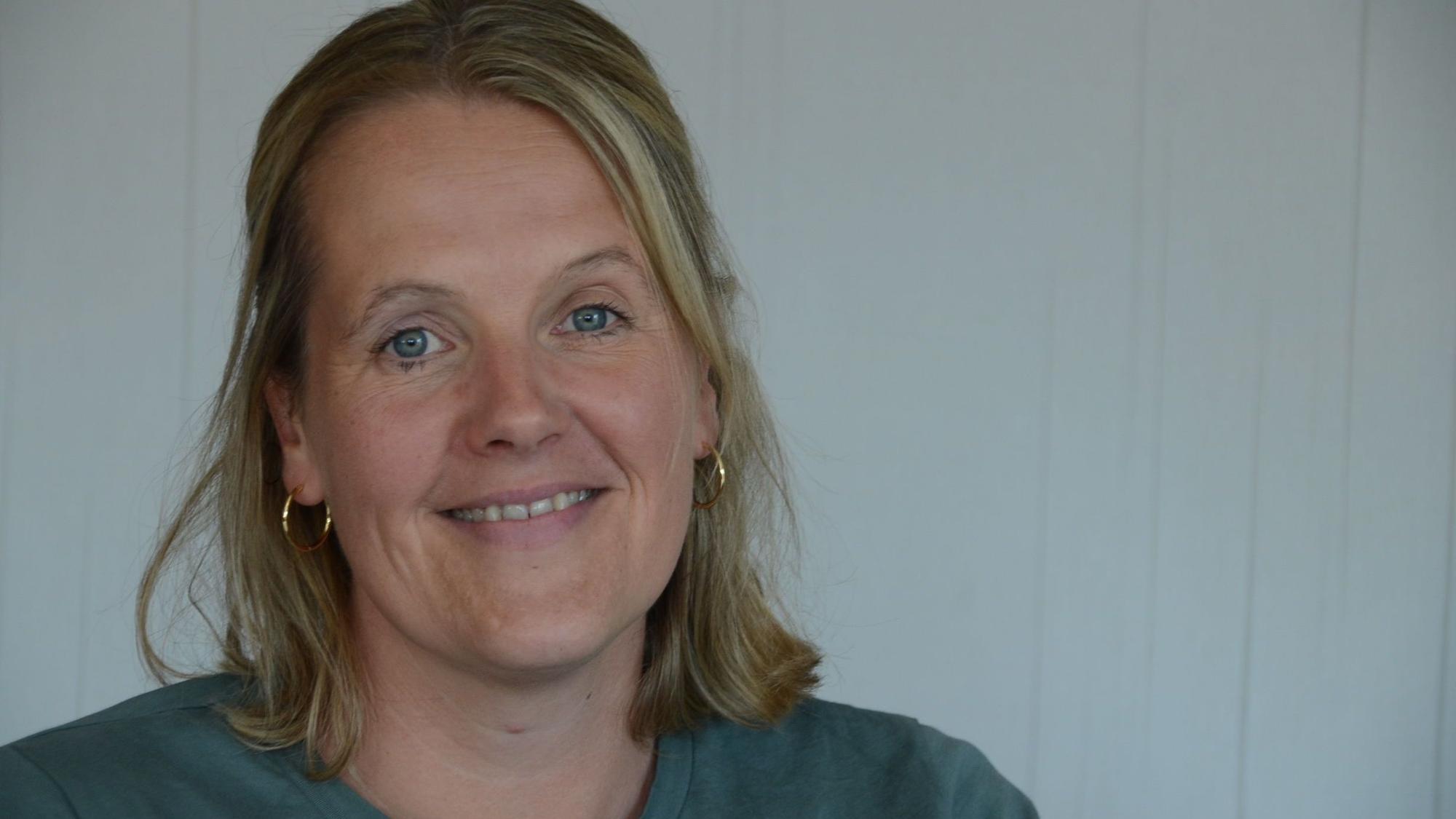 Eine blonde Frau in einem grünen T-Shirt.