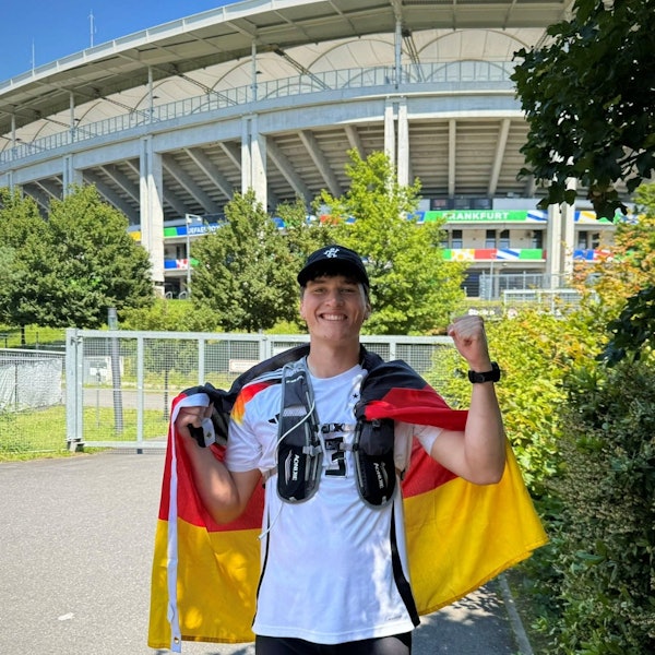 Junger Mann mit einer Deutschlandfahne und einem Deutschlandtrikot