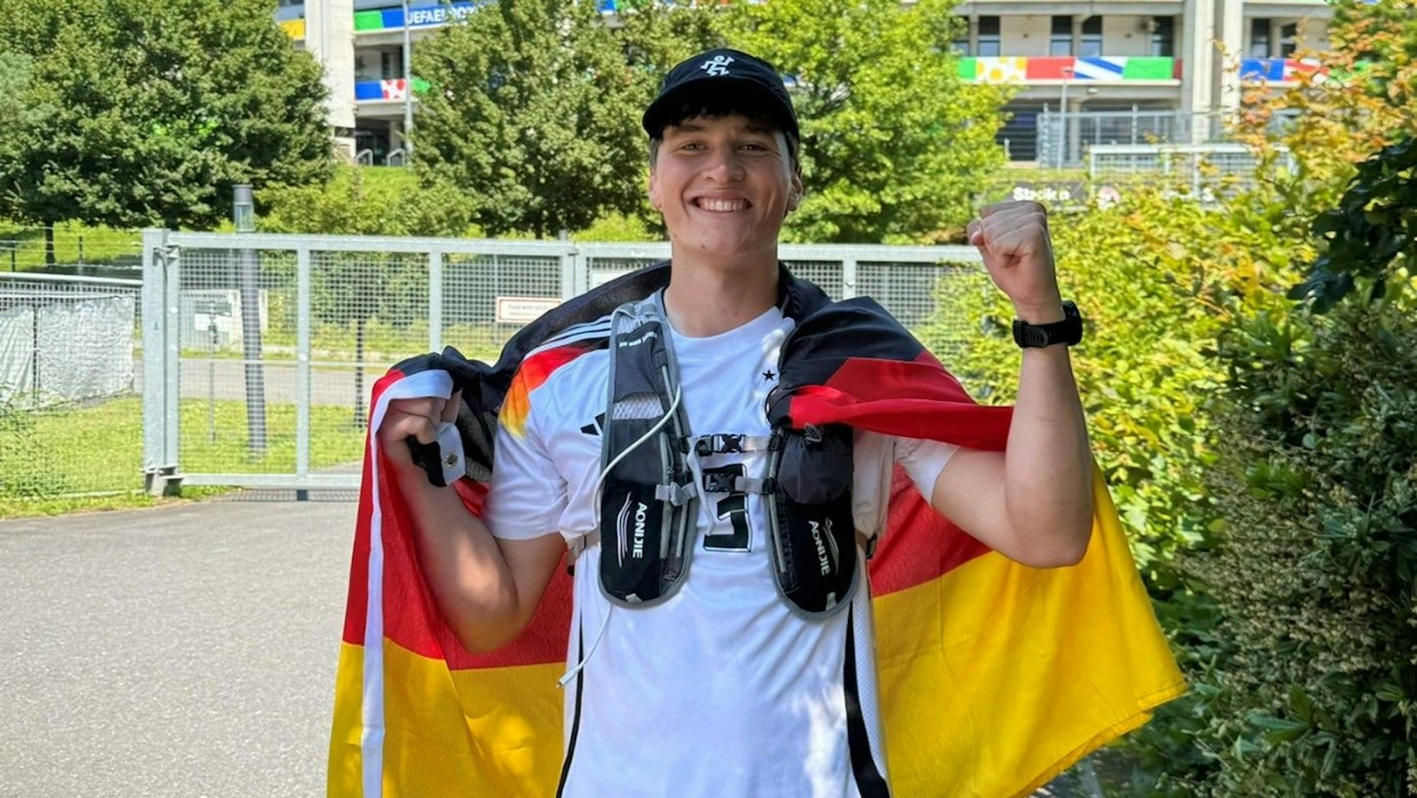 Junger Mann mit einer Deutschlandfahne und einem Deutschlandtrikot