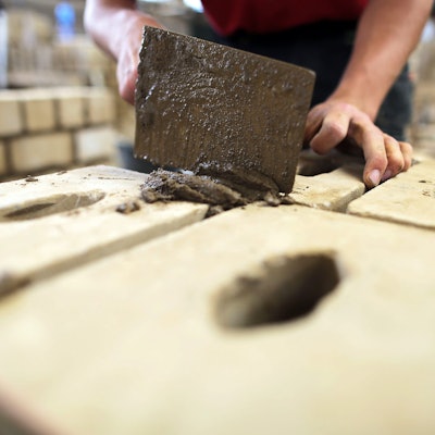 Ein Auszubildender zum Maurer arbeitet im Ausbildungszentrum Butzweilerhof an einer Mauer.