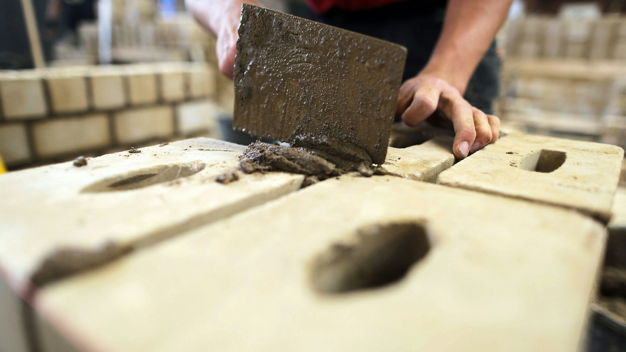 Ein Auszubildender zum Maurer arbeitet im Ausbildungszentrum Butzweilerhof an einer Mauer.