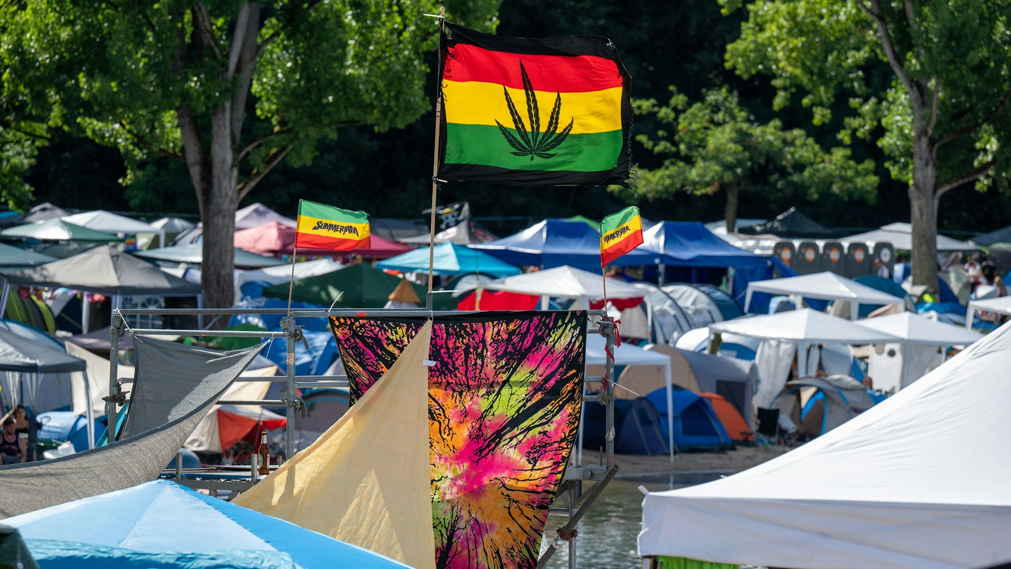 Eine Fahne an einem Zelt beim Summerjam zeigt ein Marihuana-Blatt.