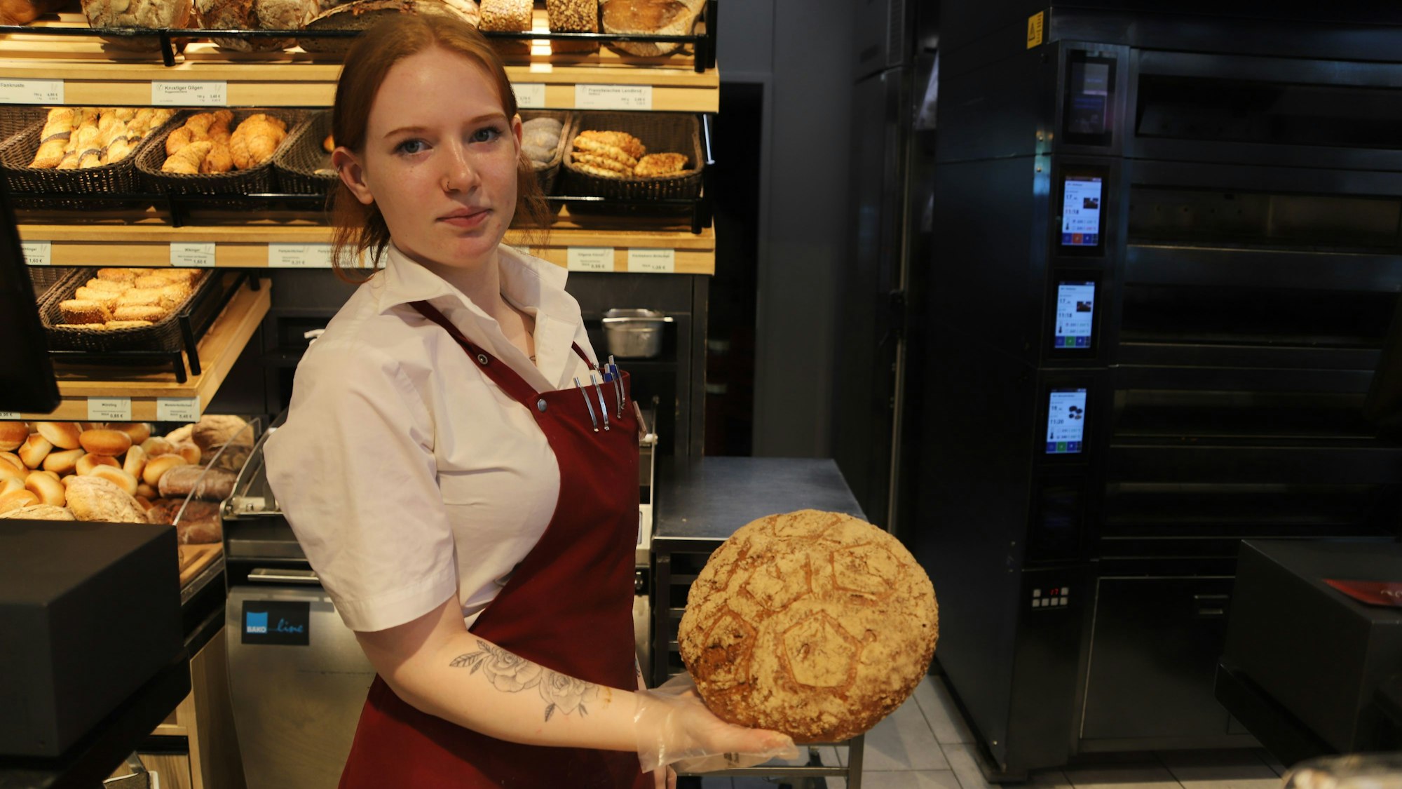 Die Auszubildende Niles zeigt die Fankruste der Bäckerei Gilgens.